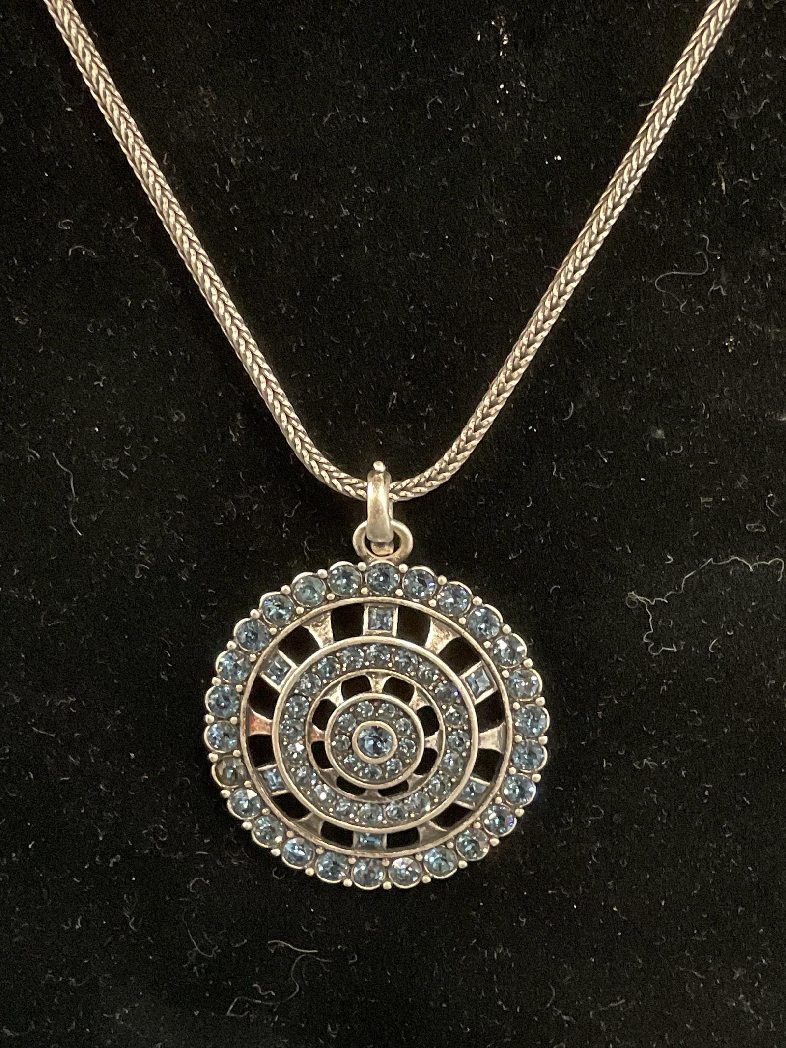 Swarovski Touchstone Blue Crystal Necklace: Touchstone by Swarovski silver tone pendant necklace with Swarovski blue crystal decoration. Signed on hang tag. Drop length approx. 8.5 inches. Some surface wear including scratching observed. Jewelr