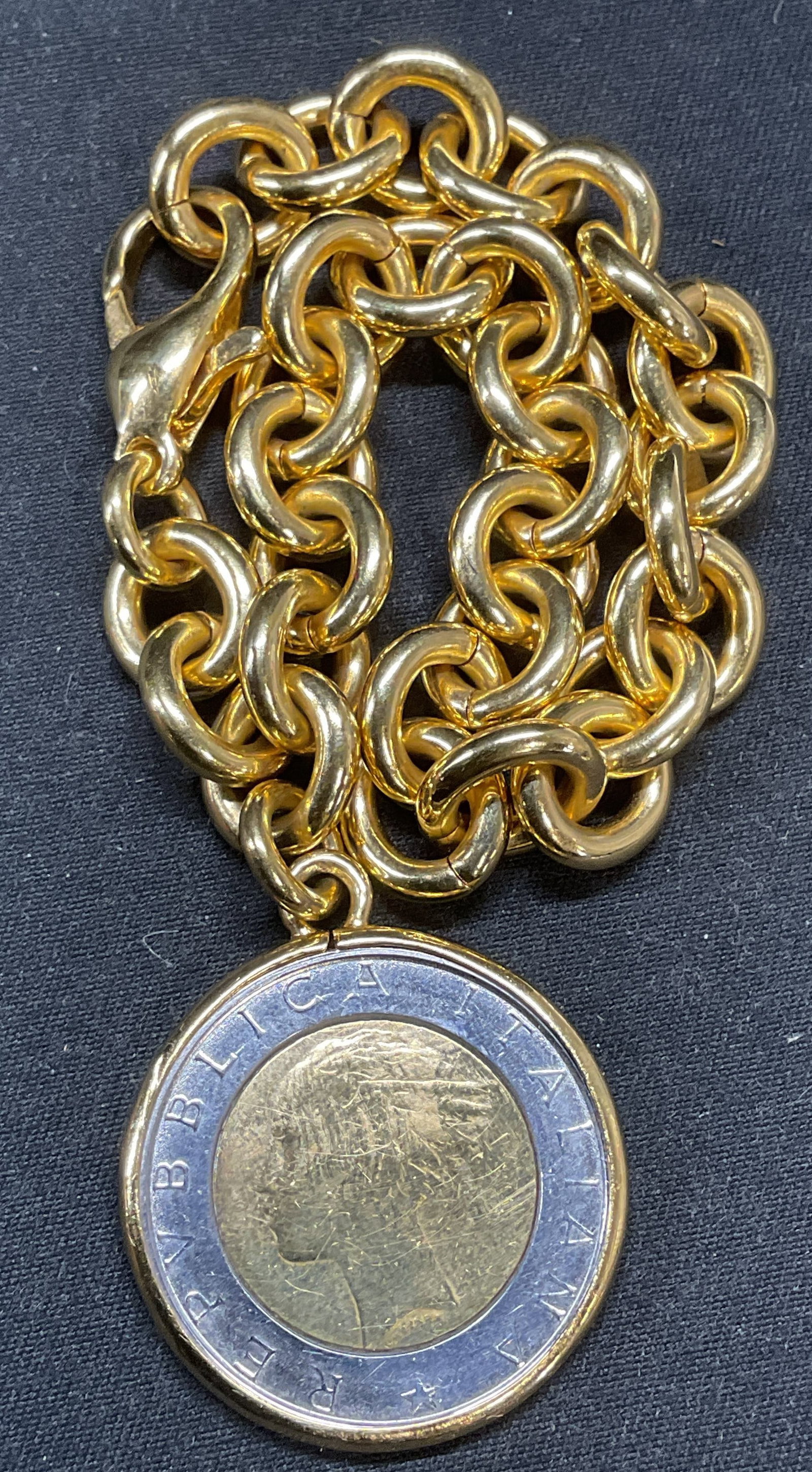 Vintage Italian Lira Coin Gold Tone Bracelet: Vintage gold tone chain bracelet with Italian 500 lira coin pendant. Drop length approx. 3.75 inches. Coin measures approx. 1 inch wide. Piece has weight. Some surface wear including scratching observ