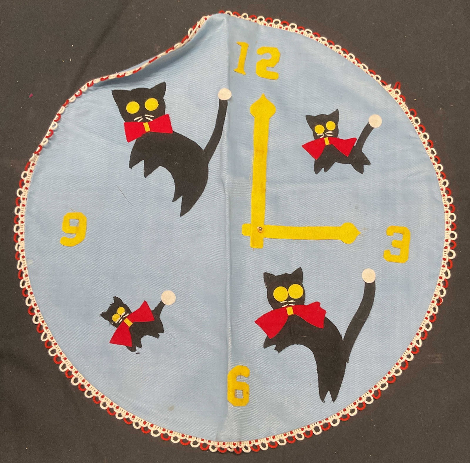 Blue Cat Clock Round Pillowcase: Handmade blue round pillowcase with felt applique cat clock design. Synthetic material. Measures approx. 12 inches wide. Some wear to material including blemishes observed. Pillowcase, blue pillowcase