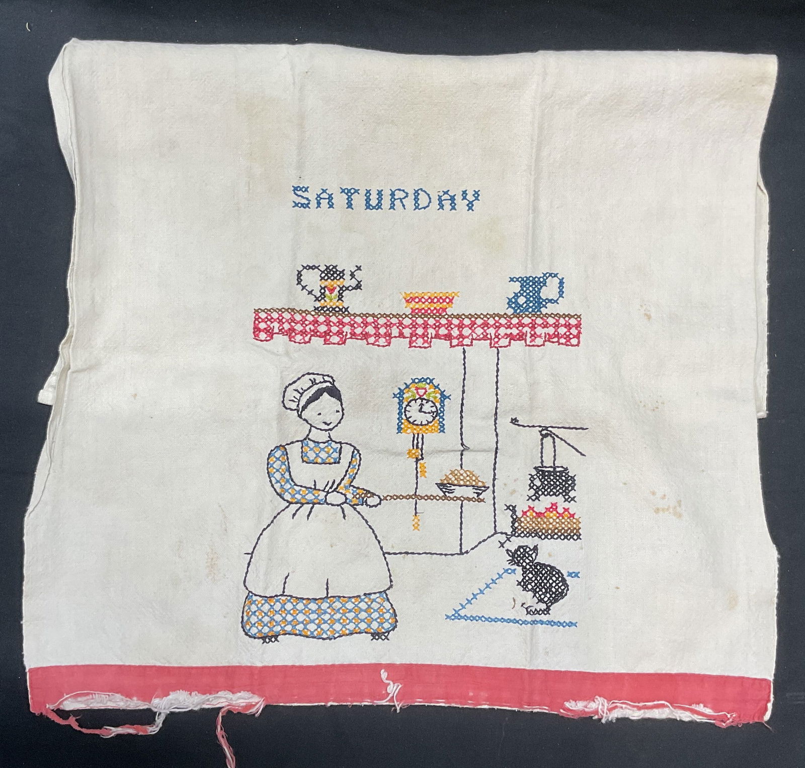 Vtg Cross Stitch Embroidered Saturday Tea Towel: Vintage cotton tea towel with cross stitch embroidery. Figural cooking motif. Reads Saturday. Measures approx. 23 x 15.5 inches. Wear to material including tearing and blemishes. Tea towel, vintage te