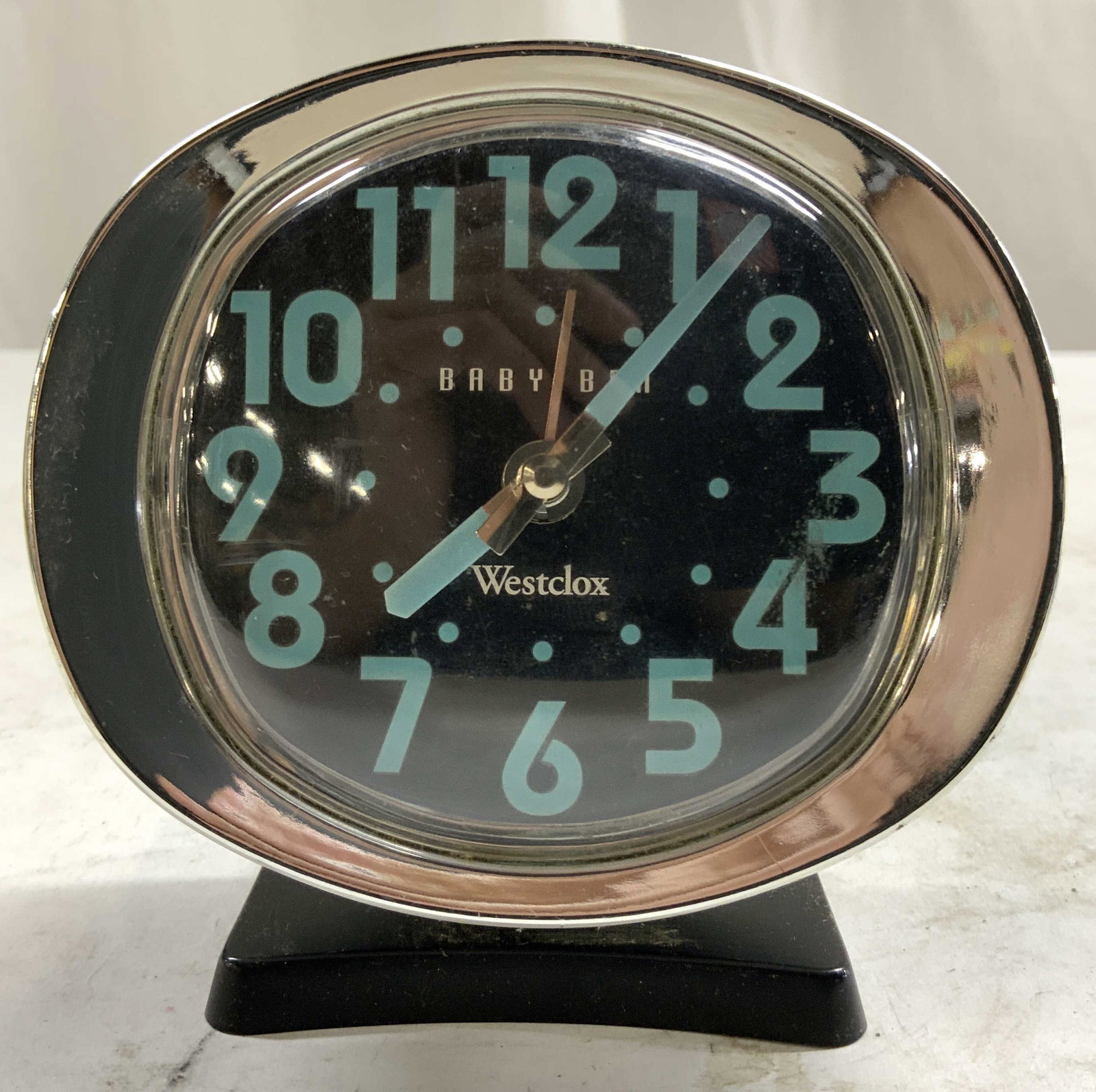 BABY BEN WESTCLOX Alarm Clock: Clock face reads BABY BEN WESTCLOX. Alarm Clock is vintage. Piece is black and silver toned. Clock face has blue toned hands and numbers. Piece measures approximately 4 inches tall 3.75 inches wide 2.