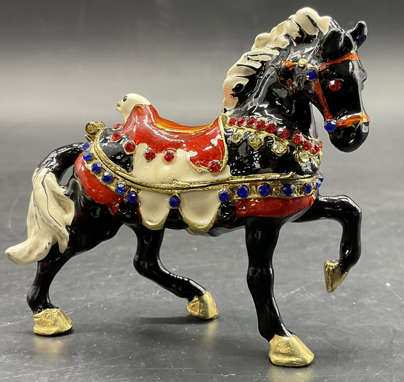Bejeweled & Enameled Horse Trinket Box: A bejeweled and enameled horse form trinket box. Opens with hinge hardware. Measures approx. 2.75H x 3W in. Surface wear consistent with age, use, and exposure. Residue present. home decor, home accen