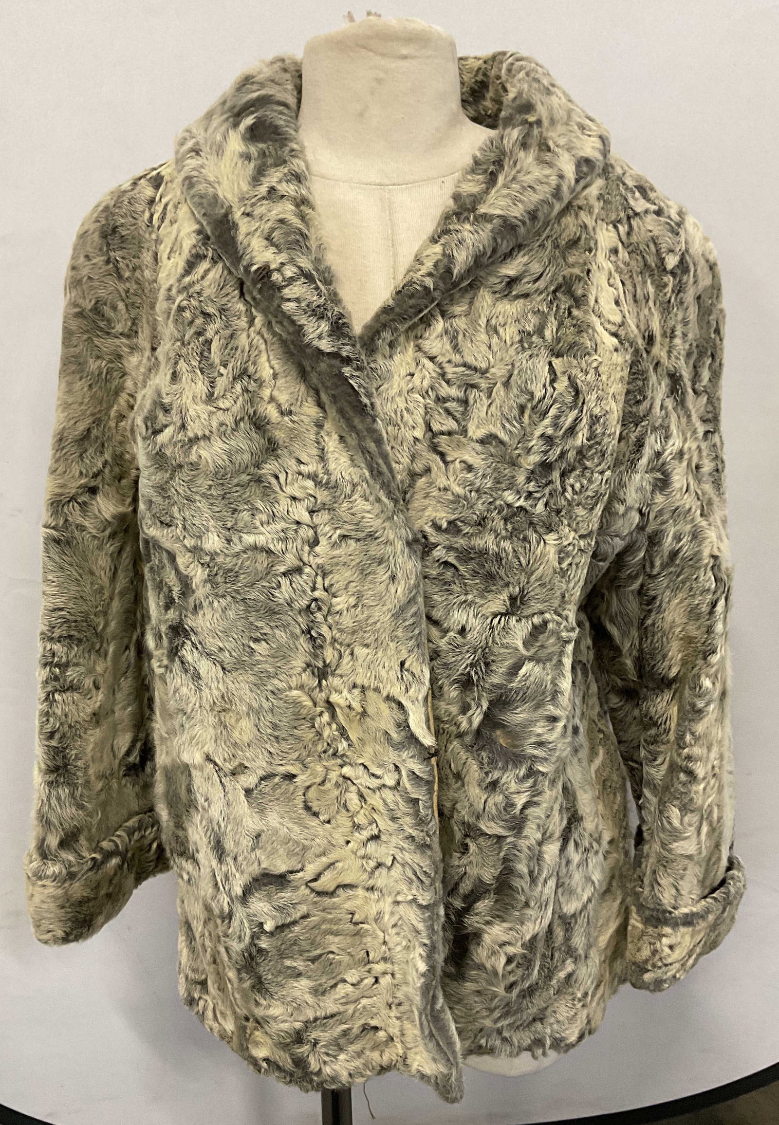 Vintage Grey Curly Fur Coat: Vintage grey curly fur coat. Possibly lamb fur. Fully lined. Exterior pockets. Hook and eye closure. Measures approx. 19 inches across chest, 25 inches from shoulder to hem. Some wear to material incl