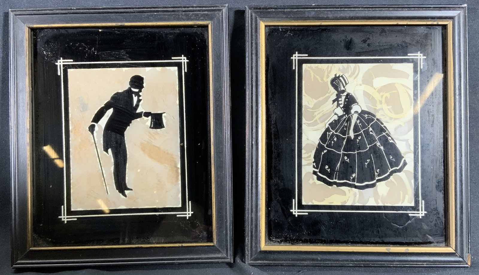 Pair Reversed Victorian Silhouettes Lithographs: Lot 2 lithographs on paper. Subjects depicts silhouettes of a man and woman in Victorian clothes. Both are individually framed in a black wooden frame with a gilt accent. Each frame measures approx. 6