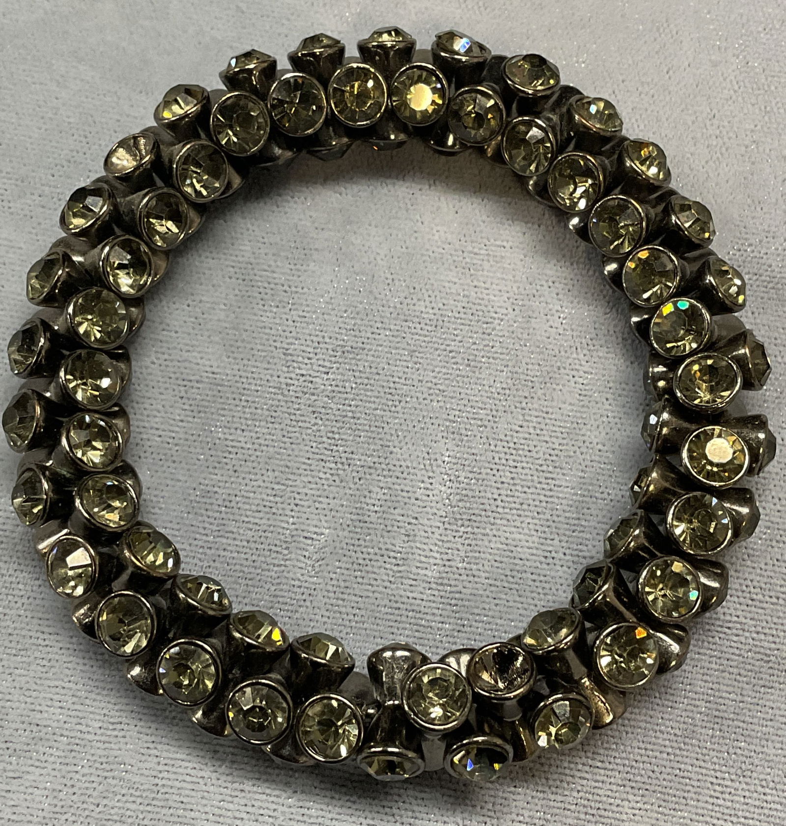 Silver Tone Crystal Bracelet: Silver tone bracelet with crystal decoration. Band has some stretch. Measures approx. 2 inches wide. Piece has weight. Some surface wear including scratching observed. Jewelry, estate jewelry, costume