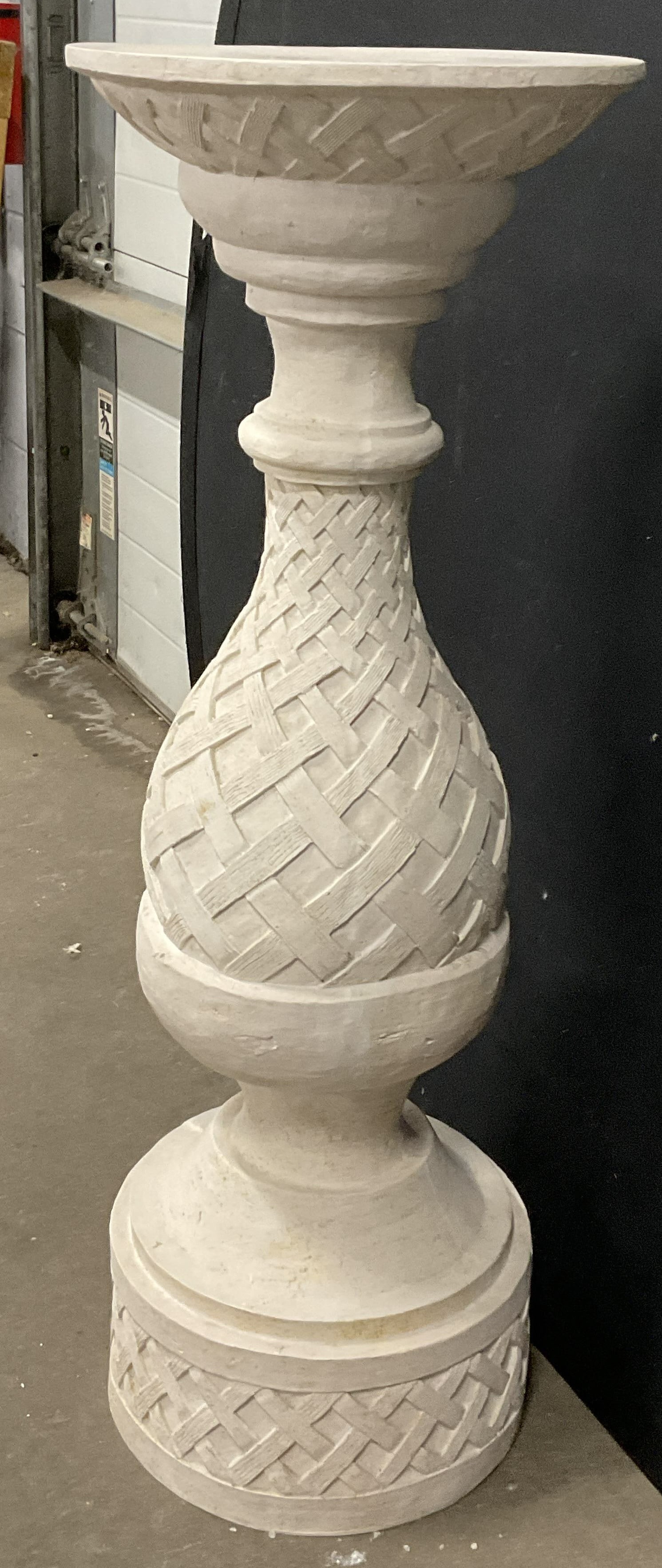Round Woven Motif Display Pedestal: White hued composite material display pedestal. Round top. Woven motif to the base. Measures approx. 13W x 37H in. Discoloration, losses to finish, and surface wear present. home decor, home accents, 