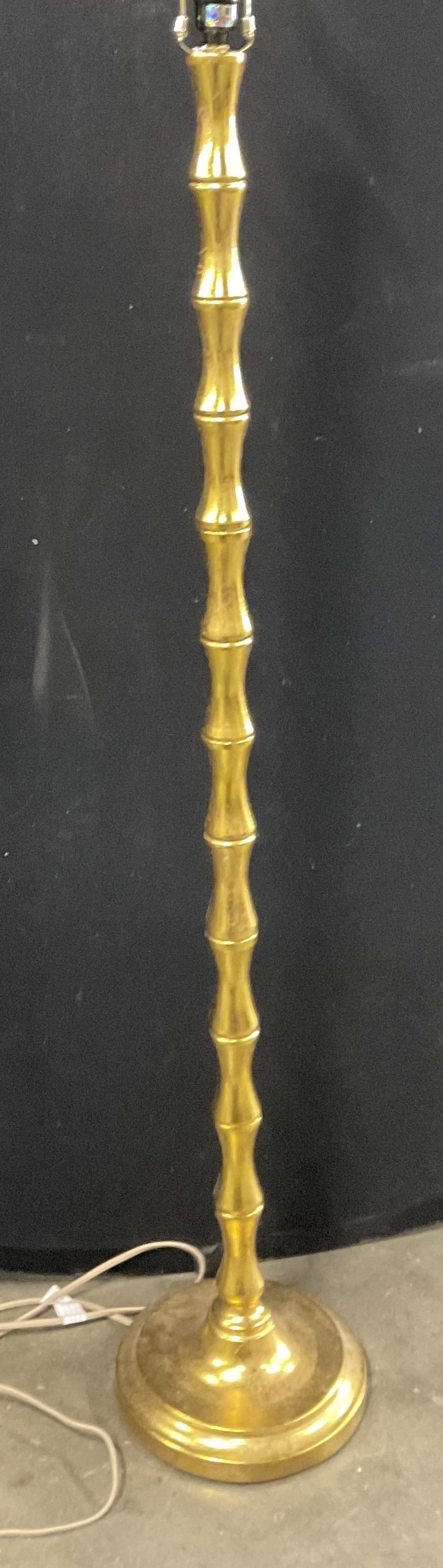 SAFAVIEH Gilt Metal Standing Floor Lamp: SAFAVIEH Gilt Metal Standing Floor Lamp. Underside tag reads SAFAVIEH. Measures approx. 63H x 10W in. Height includes harp. Corded. Not tested for function. Surface wear consistent with age, use, and