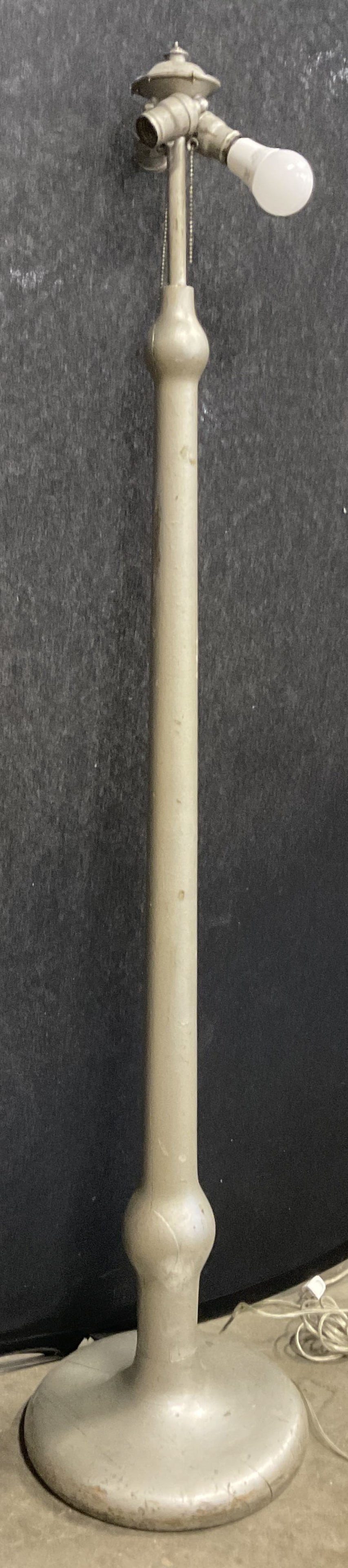 Painted Metallic Silver Wood Floor Lamp: A standing wooden floor lamp painted with a silver metallic paint. Measures approx. 61H x 13W in. Corded, not tested for function. Cracking, losses to paint, and surface wear present. home decor, home