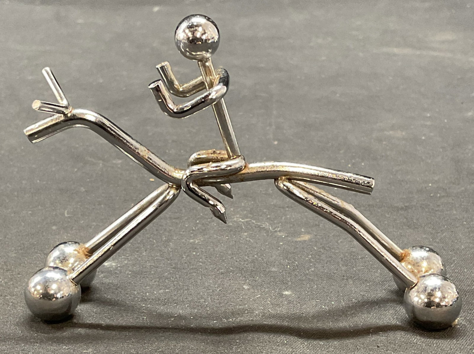 Silver Tone Figure on Horseback: Silver tone metal figural. Figure on horseback. Measures approx. 3.75 x 1 x 2.75 inches. Some surface wear including scratching observed. Figural, silver tone figural, horse figural, figure on horseba
