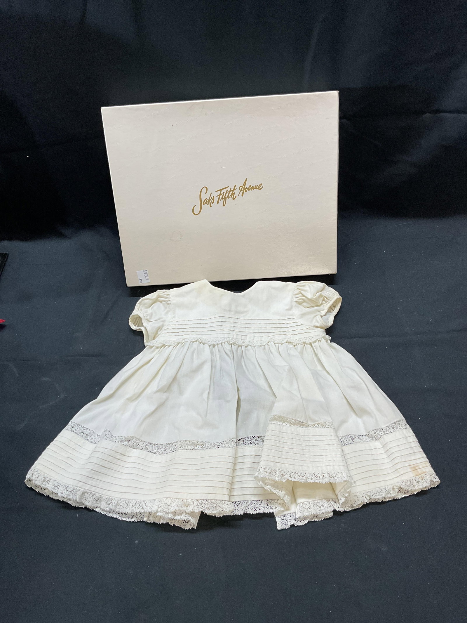 Vtg Nanouchka Saks Fifth Ave Baby Dress: Vintage Nanouchka white cotton and lace baby dress. Made in France exclusively for Saks Fifth Avenue baby boutique. Measures approx. 10 inches across chest, 13 inches shoulder to hem. Some wear to mat