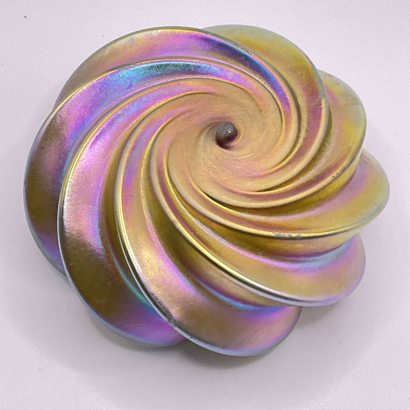 Iridescent Art Glass Swirl Paperweight: Multicolored Iridescent Art Glass Swirl Paperweight. Measures approx. 1.5H x 3.25W in. Surface wear consistent with age, use and exposure. Losses to finish. Pontil / imperfection to underside. home de