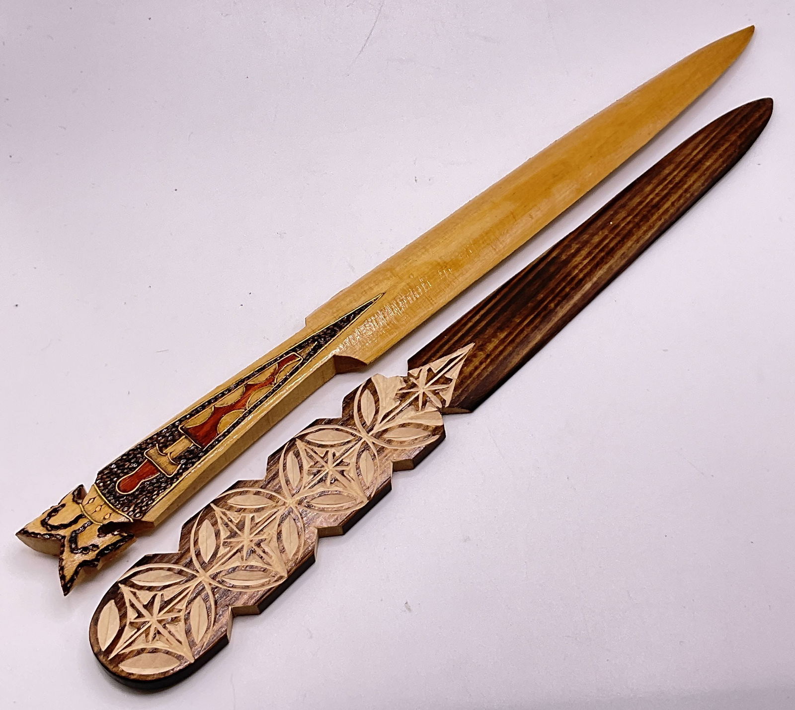 Lot 2 Vintage Carved Wood Letter Openers, Poland +: Two vintage carved wood letter openers. One possesses a partial sticker to the underside which reads POLAND. It is etched MADE IN POLAND on the underside as well. Larger piece measures approx. 10.75L