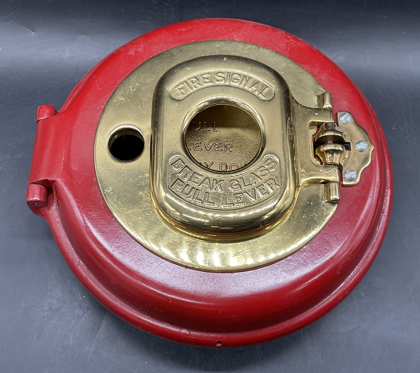 Vntg Iron Break Glass Pull Lever Fire Signal Box: A vintage red painted iron fire signal pull box. Brass hued polished metal obverse. Obverse reads Break Glass Pull Lever Fire Signal. Interior reads Pull Lever Way Down And Let Go. Weighty piece. Meas