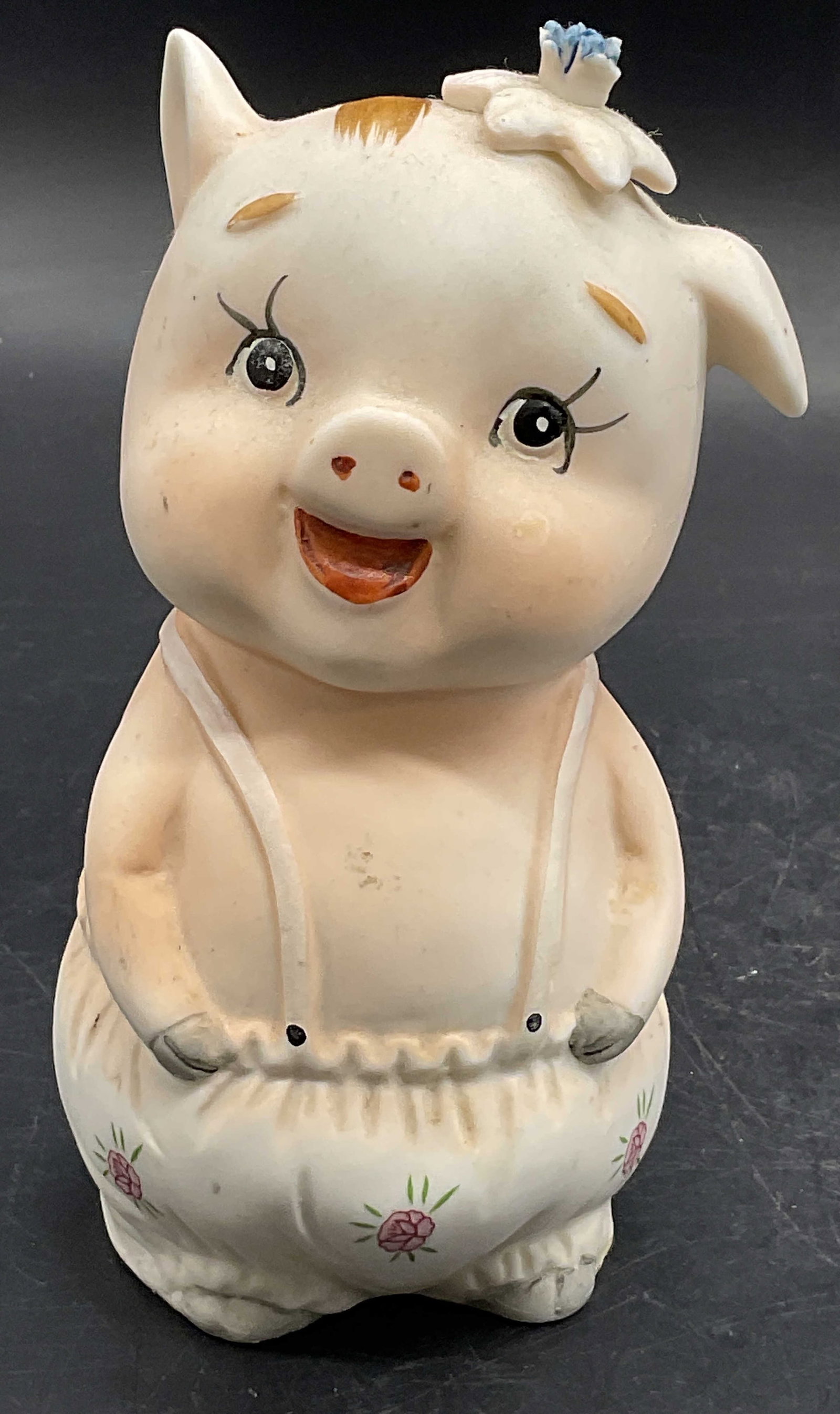 Vintage Hand Painted Ceramic Pig Figural Coin Bank: A vintage hand painted ceramic pig figural coin bank. Measures approx. 5H x 2.5W in. Rubber stopper to the underside. Surface wear, wear to paint, and discoloration present. Pitting and chipping prese