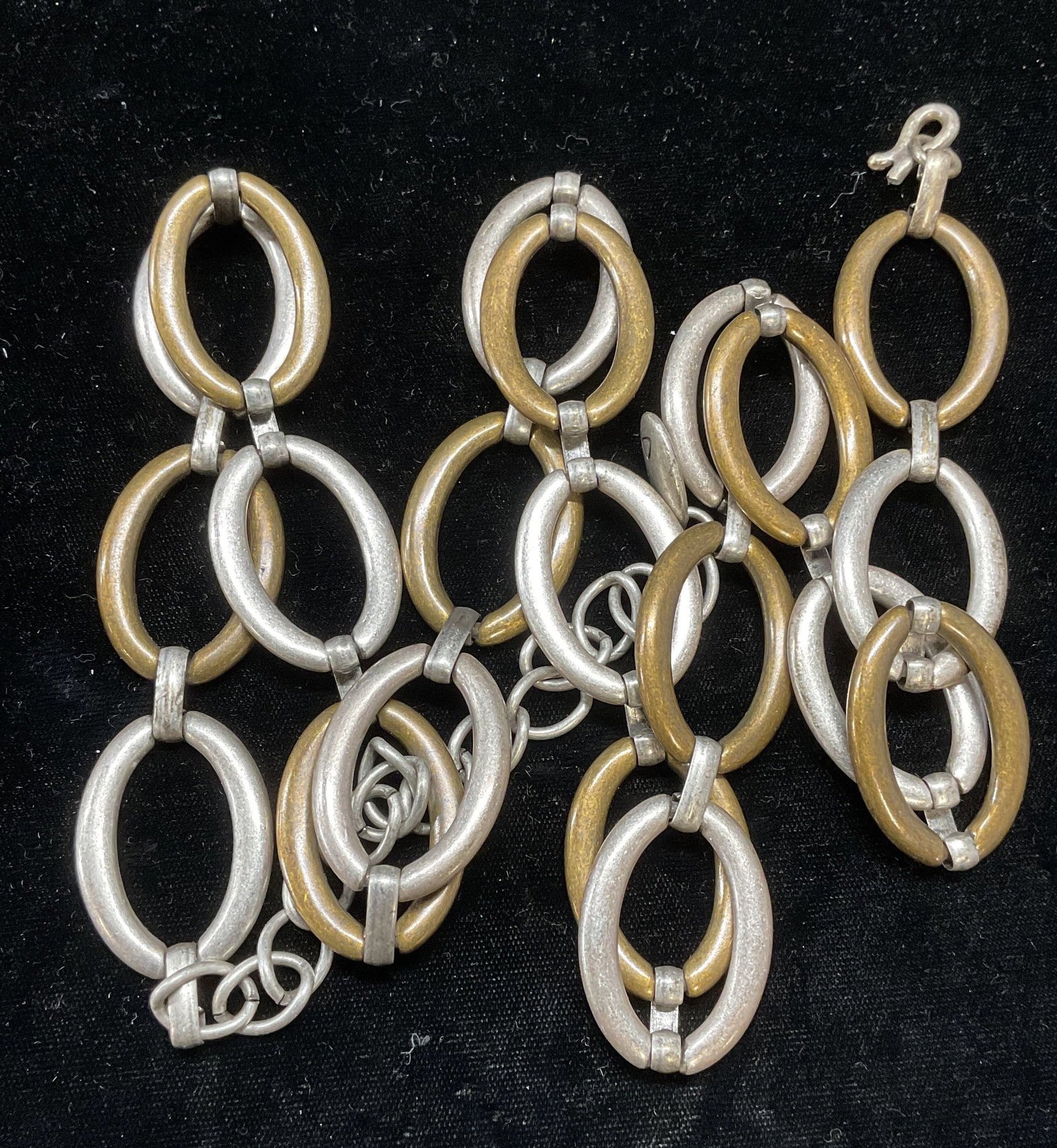 Signed Silver Tone & Brass Chain Belt/Accessory: Silver tone and brass chain belt or accessory. Signed on hang tag with makers mark. Measures approx. 39 inches long. Piece has weight. Clasp needs repair. Some surface wear including scratching observ
