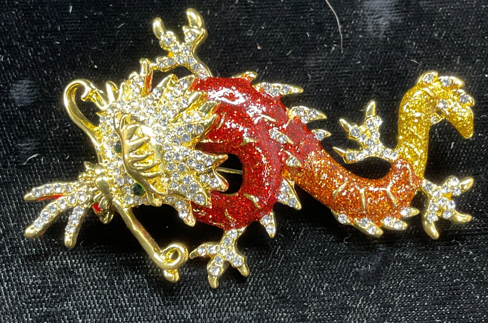 Gold Tone Enamel Crystal Dragon Brooch Pendant: Gold tone dragon motif brooch/pendant with multicolor enamel and colorless crystal decoration. Hinge pin and bail on underside. Measures approx. 2.75 x 1.75 inches. Some surface wear including scratch
