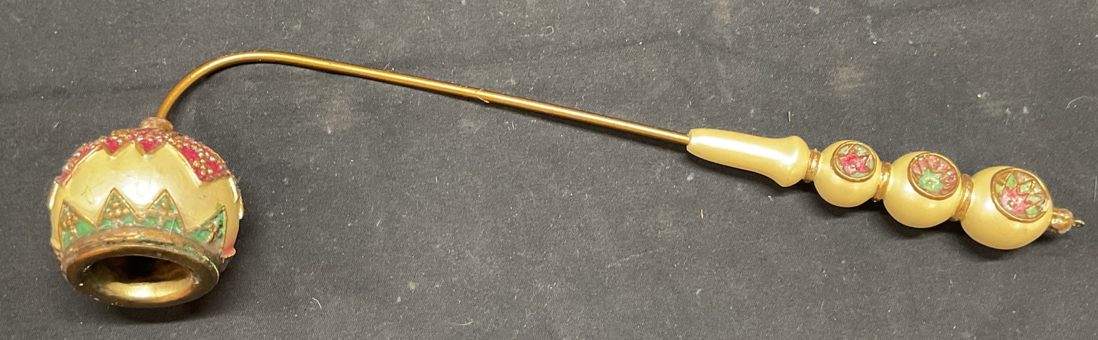Pearlescent Gold Tone Candle Snuffer: Candle Snuffer with pearlescent handles and gold tone decoration. Floral design in pink and green. Composite material. Measures approx. 10.5 inches long. Some surface wear including residue and small 