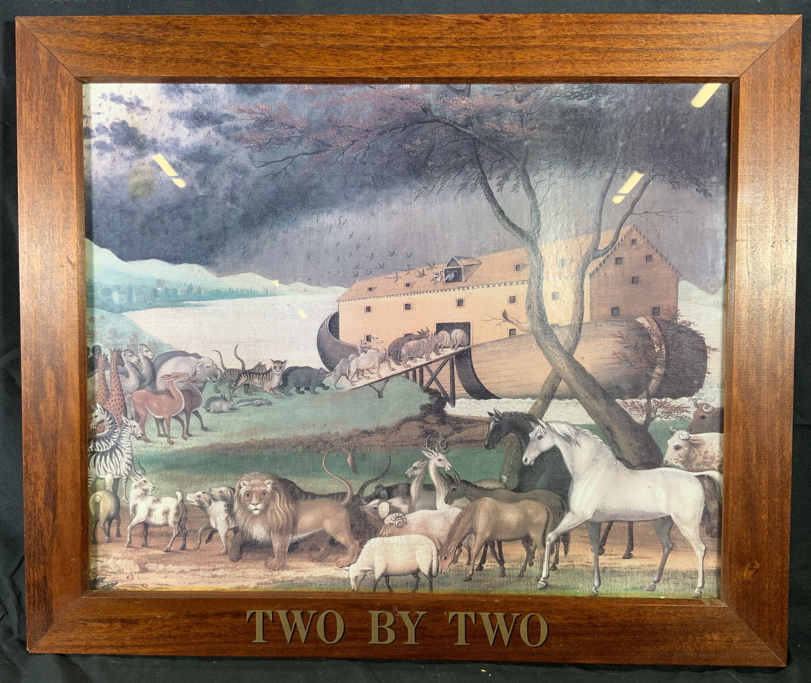 After Edward Hicks Noahs Arc Framed Lithograph: Lithograph on paper. Art after Edward Hicks 1846 print Noahs Arc. Subject depicts the animals on Noahs arc walking in line onto the arc. Framed in a brown wooden frame, frame reads Two by Two. Frame m
