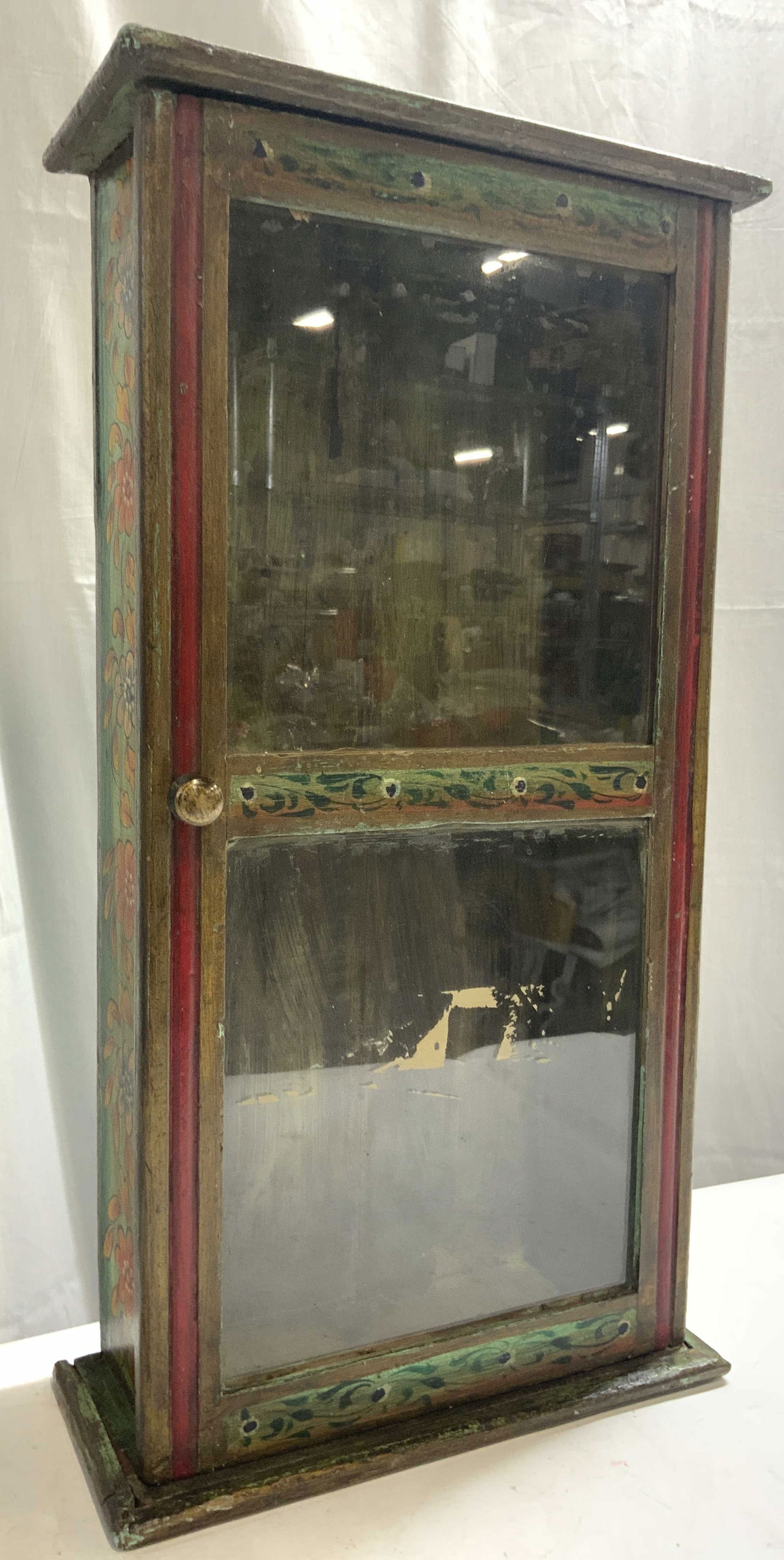 Vntg Hand Painted Wood Wall Displays Cabinet: Wall cabinet is vintage and wooden. Piece appears to be hand painted. Interior has 1 shelf. Piece has windowed door. Piece has knob form handle. Cabinet measures approximately 24.5 inches tall 13 inch