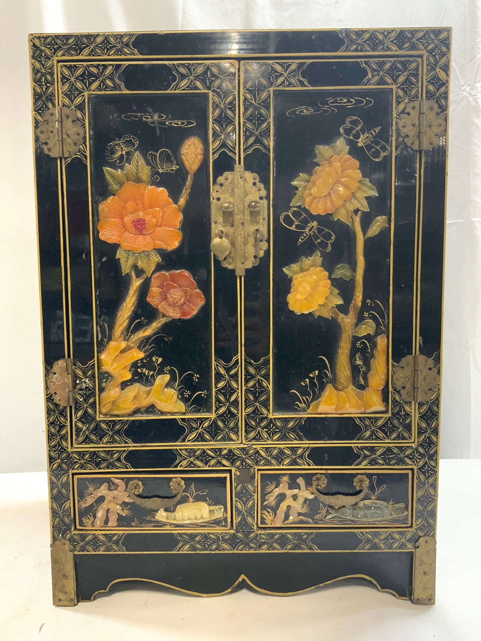 Vtg Asian Cabinet W Carved Jade & Painted Detail: Cabinet is vintage. Piece has intricately carved jade floral, stem and leaf detail. Piece has double cabinet door with drawer inside and 2 exterior drawers. Piece has hand painted gilt pattern & butte