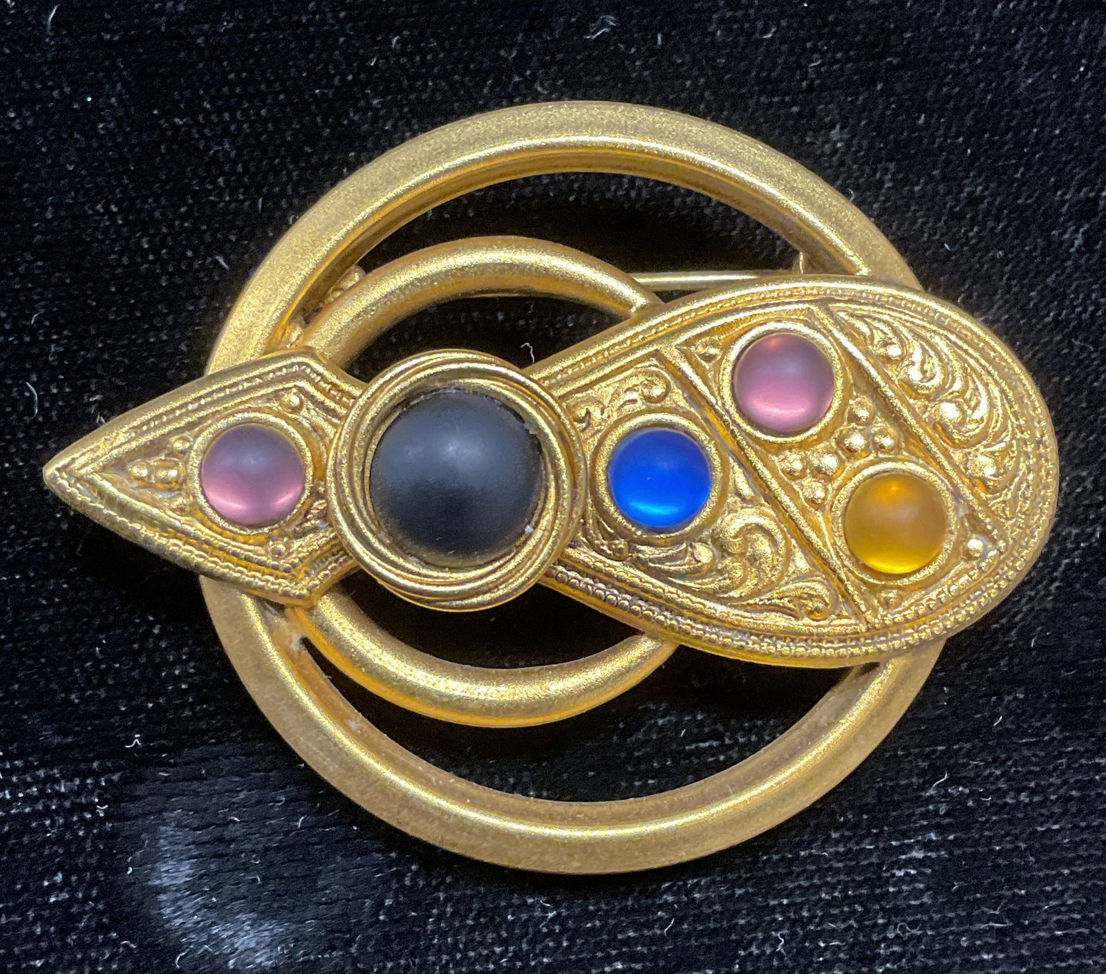 Vintage Dina Panagopoulos Gold Tone Brooch: Vintage Dina Panagopoulos gold tone brooch with arrow motif. Multicolor faux stone cabochons. Signed on underside. Hinge pin on underside. Measures approx. 2 x 1.5 inches. Some surface wear including 