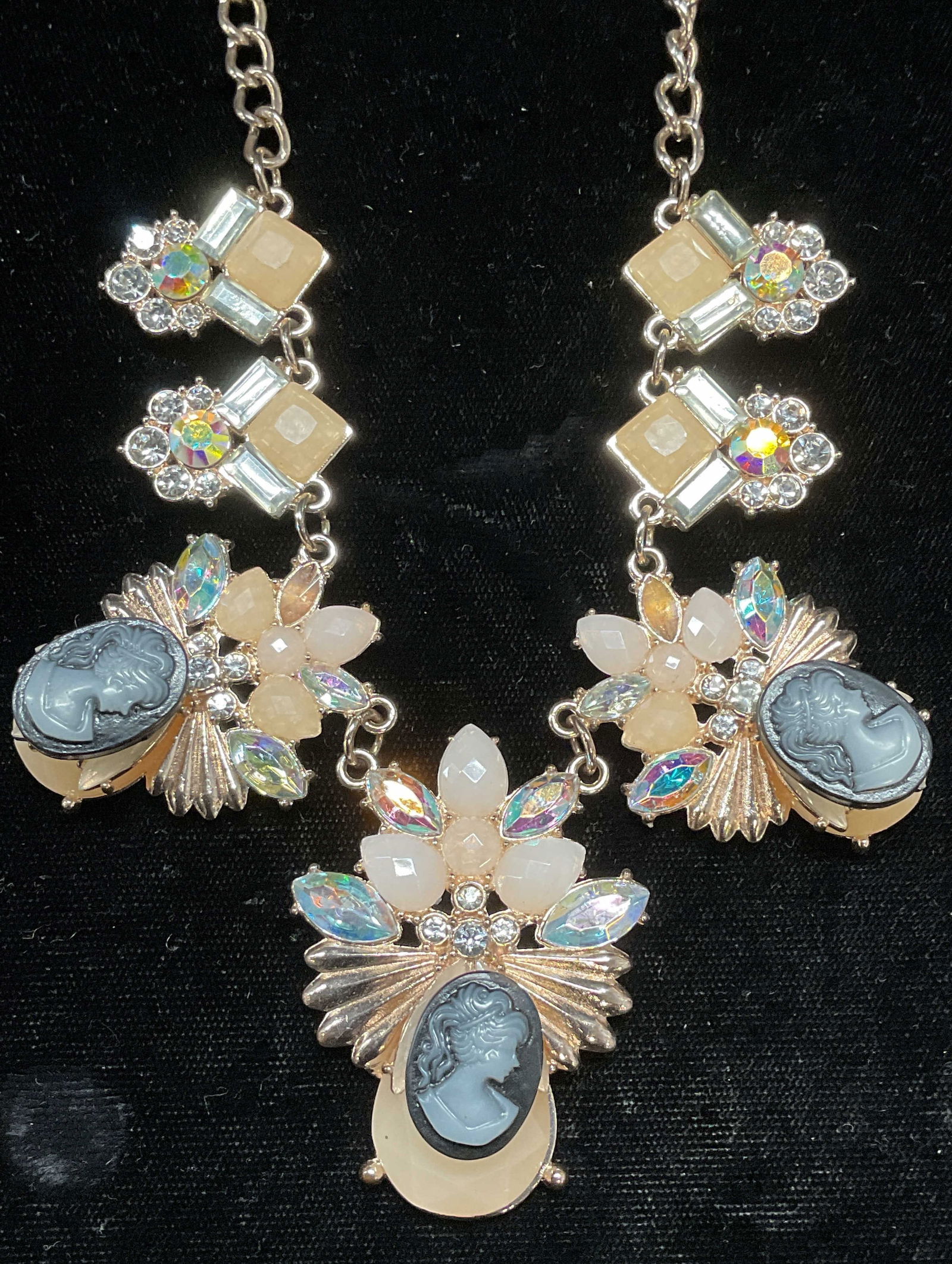 Vtg Gold Tone Crystal Cameo Pendant Necklace: Gold tone pendant necklace. Peach toned and colorless crystal decorated panels and black and white lucite cameo pendants. Drop length approx. 9.25 inches. Largest pendant approx. 2 x 1.5 inches. Some