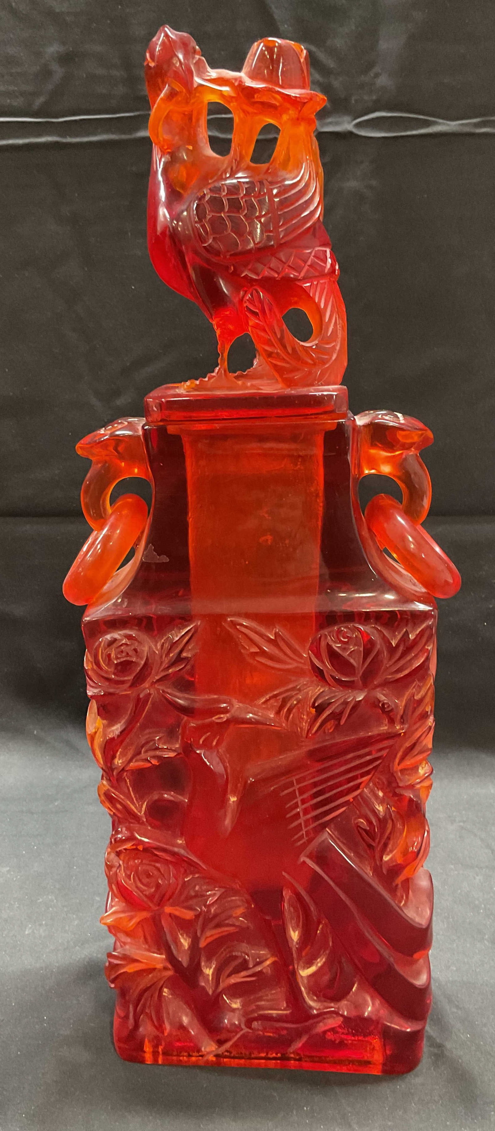 Asian Carved Faux Amber Bird Vase & Cover: Asian carved faux amber lucite vase with cover. Bird and flower design. Measures approx. 5.25 x 2.5 x 15.5 inches including lid. Some surface wear including scratching and residue observed. Faux amber