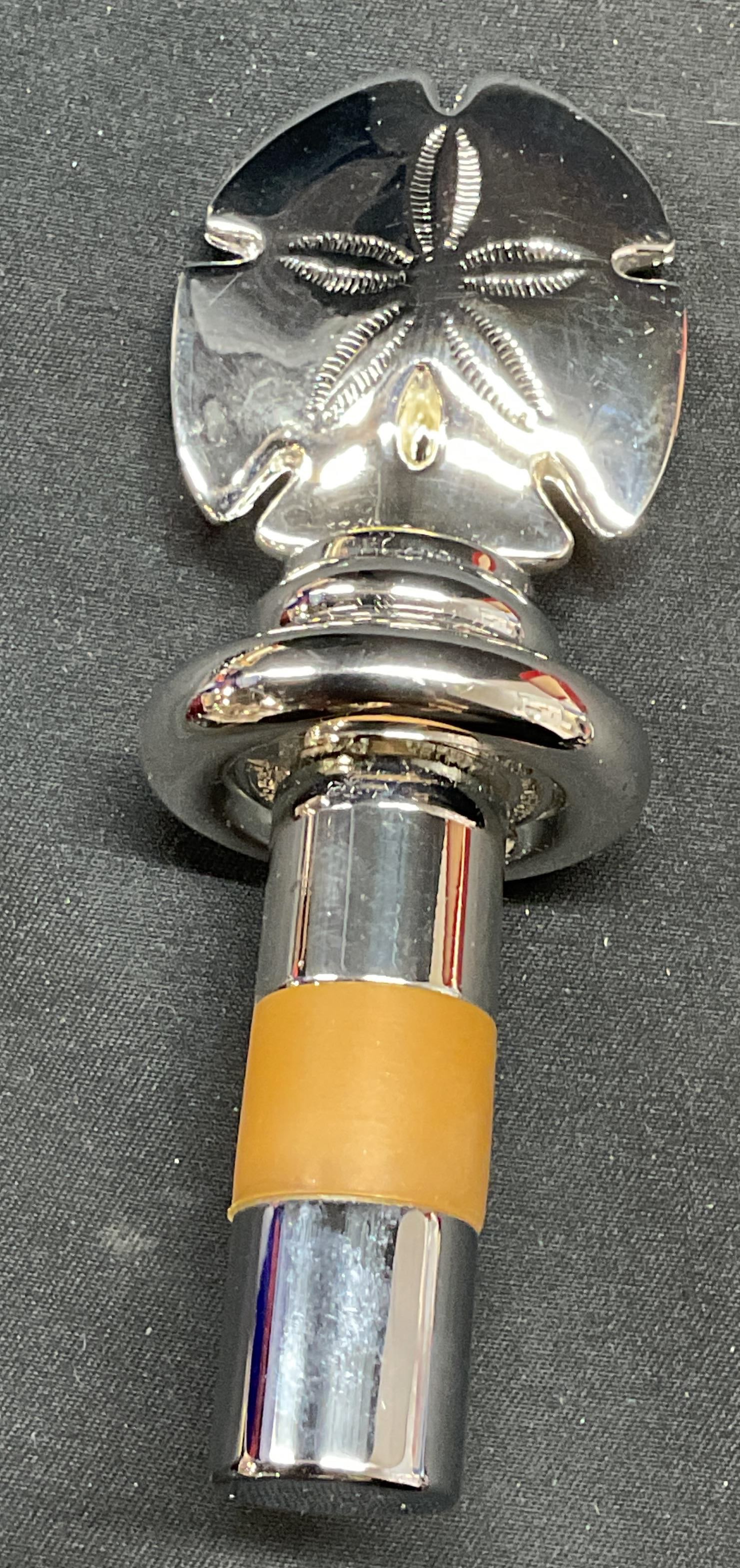 Hans Turnwald Sand Dollar Wine Stopper NIB: Hand Turnwald silver tone metal wine stopper with sand dollar motif finial. Signed on underside. New in box. Measures approx. 4 inches long. Piece has weight. Some surface wear consistent with exposur
