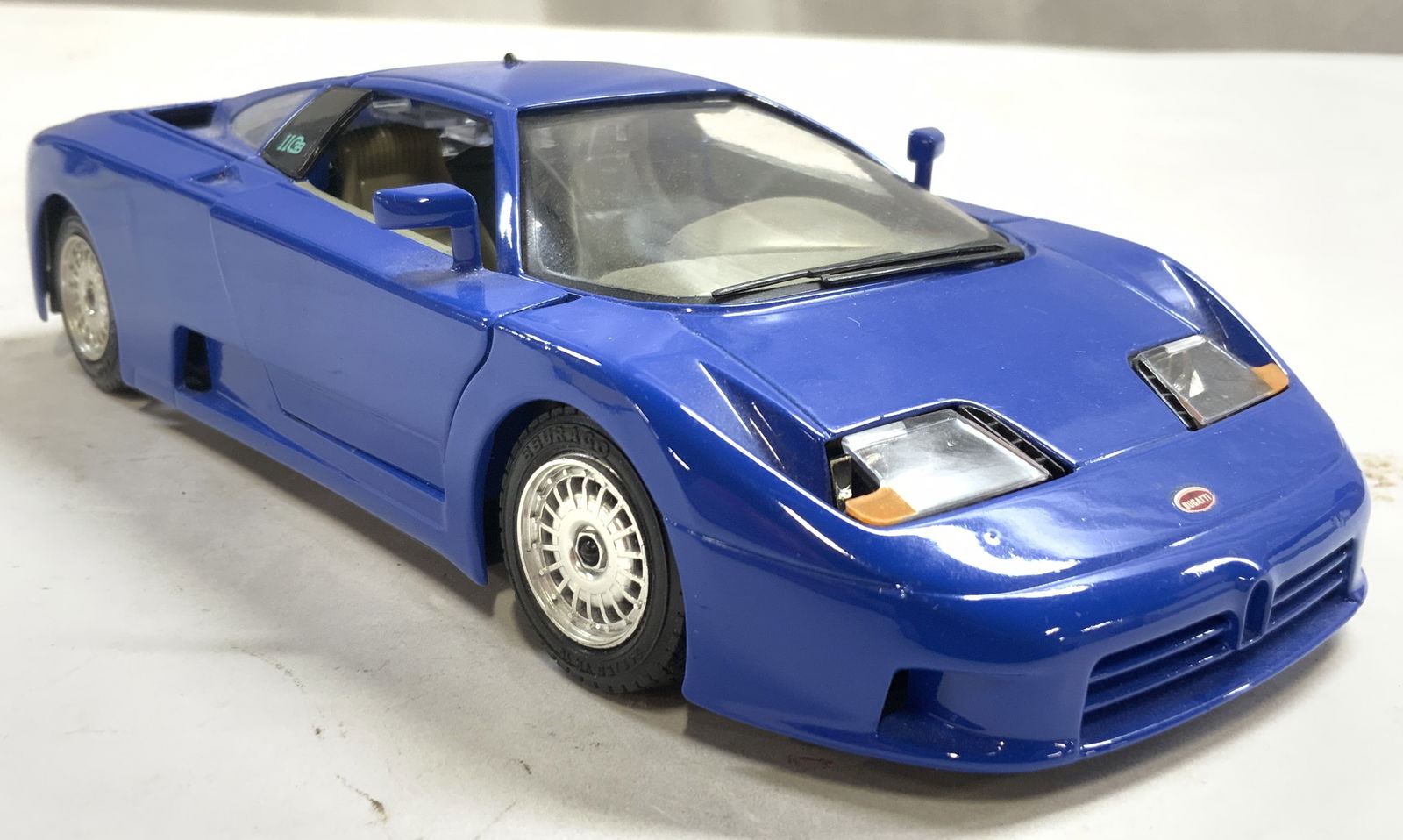 BUGATTI EB110 BURAGO Vntg Blue Die Cast Car: Underside reads BURAGO BUGATTI EB110. Die cast car is blue toned and metal with plastic elements. Piece has articulated rear engine bay, & butterfly doors. Die cast car appears to be vintage. Piece me