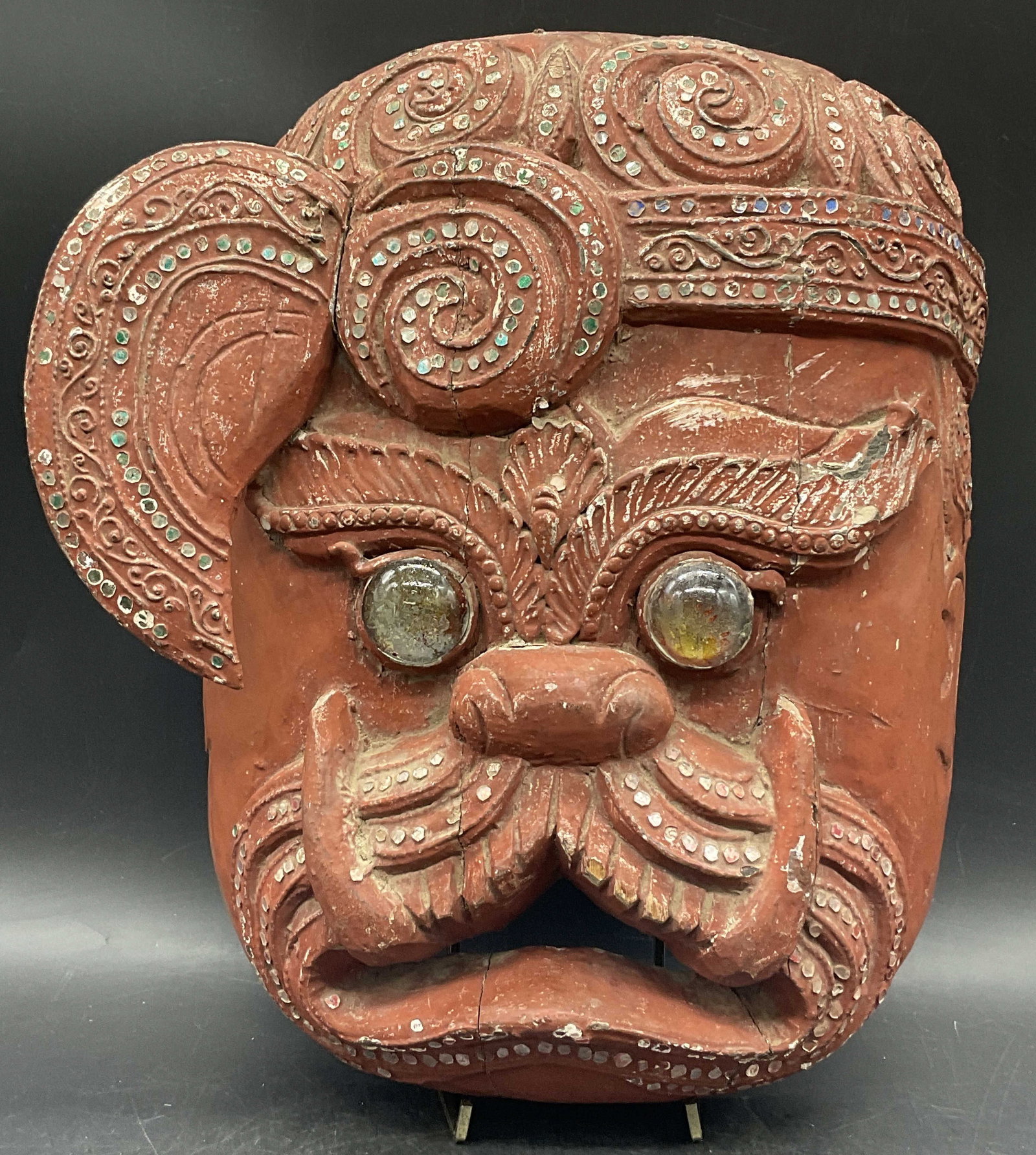 Handcrafted Carved Wood Asian Figural Mask: Handcrafted Carved Wood Asian Figural Mask with Glass Eyes. Primarily red hued. Measures approx. 12L x 9.5W in. Surface wear, cracking, discoloration, chipping, losses, and loose pieces. home decor, h