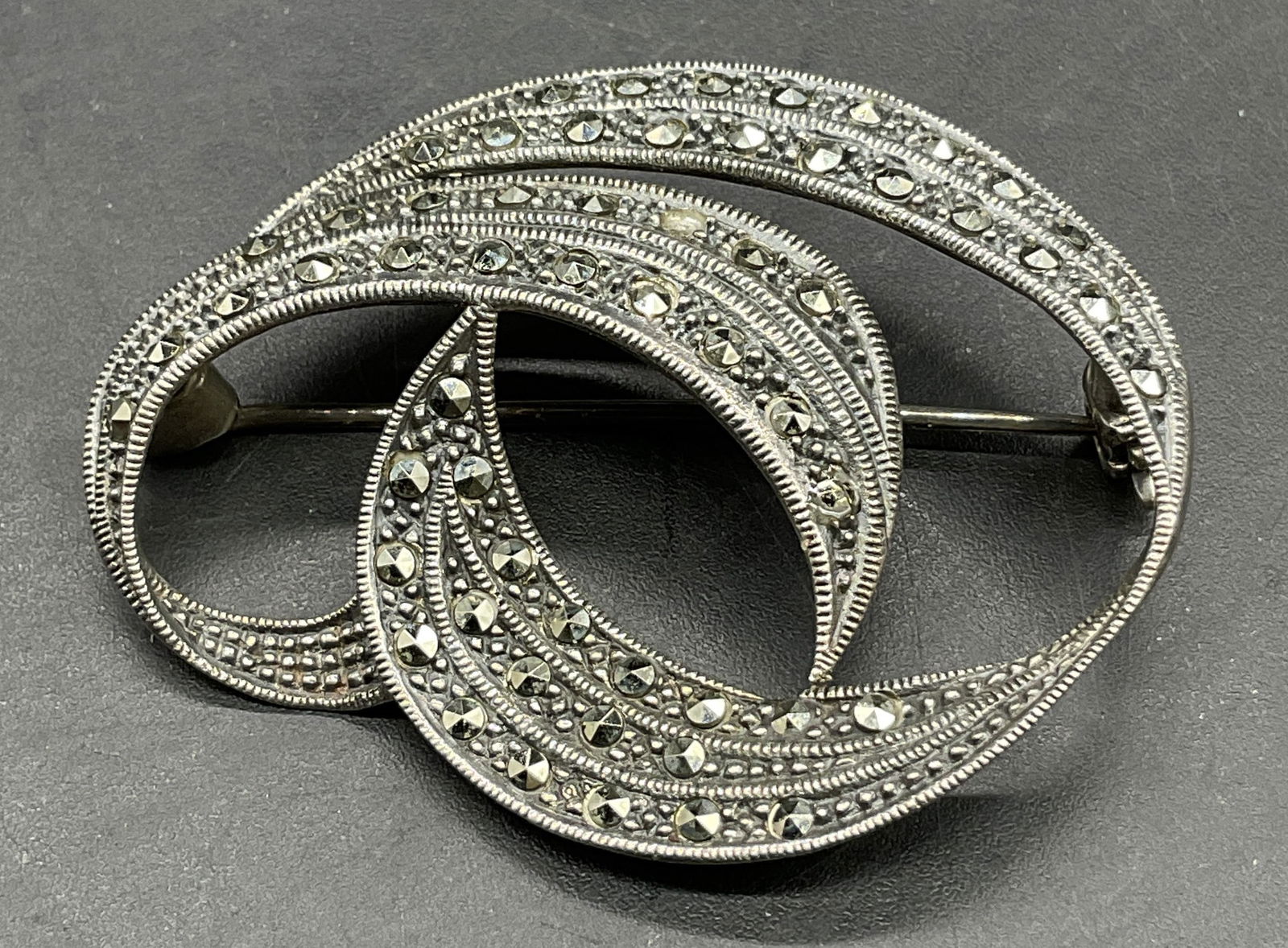 825 S Silver Vintage Marcasite Brooch: 825 S Silver Vintage Marcasite Brooch. Geometric brooch. Marked 825 S on reverse. Metal pin closure to reverse. Measures approx. 1.5L x 1.25W in. Total weight .21 ozt. Some missing marcasite. Surface
