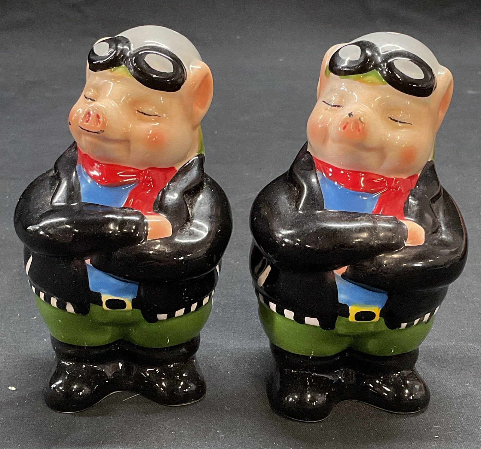 Pair Ceramic Biker Pig Salt & Pepper Shakers: Pair of ceramic biker pig figural salt and pepper shakers. Measure approx. 2.25 x 2.25 x 4 inches each. Both pieces have some surface wear including scratching observed. Salt and pepper shakers, ceram