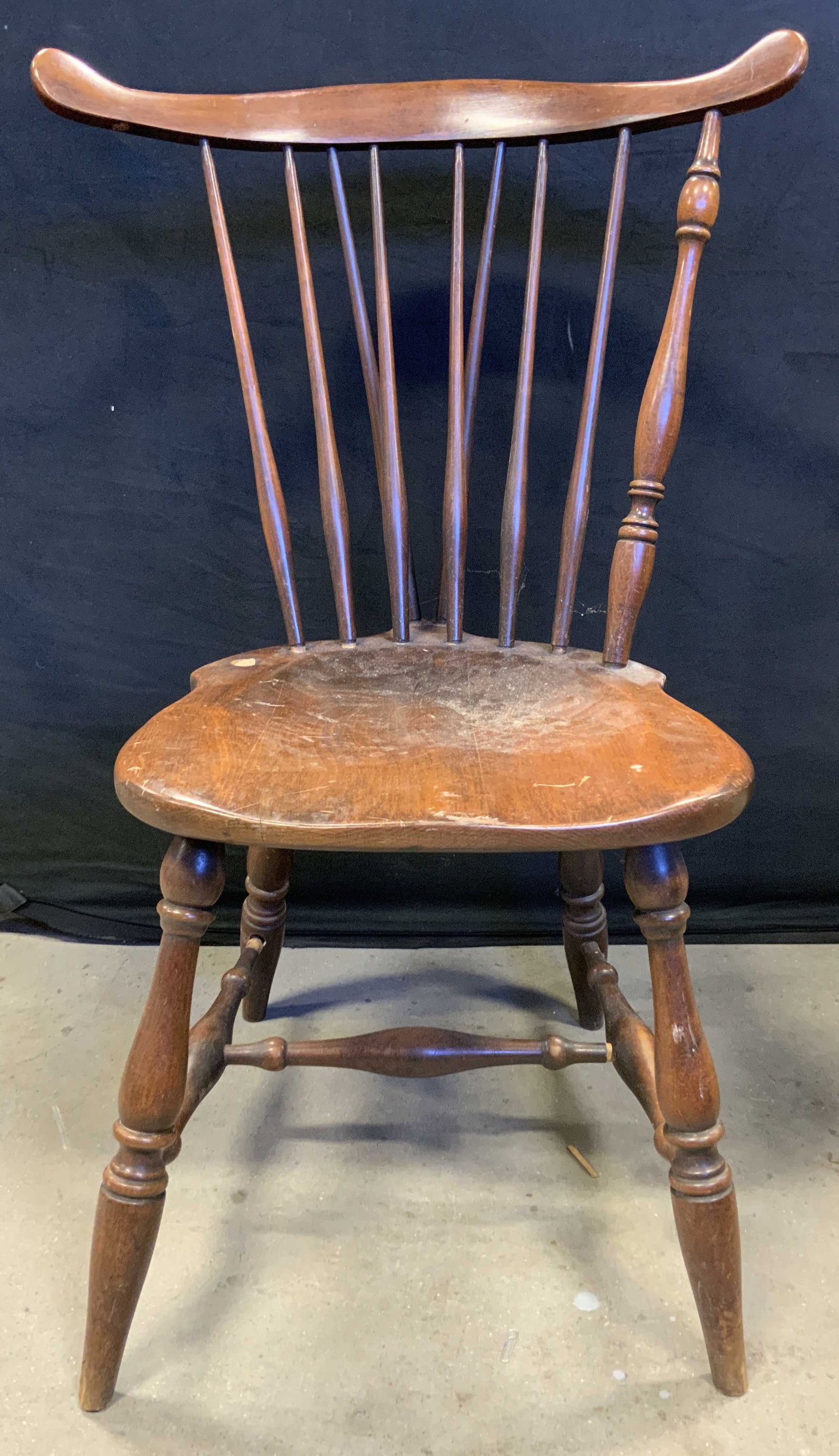 Vintage Spindle back Wooden Chair: Chair is vintage and wooden. Piece has spindle backrest. Chair is mahogany toned. Chair legs have stretcher in between. Chair measures approximately 35 inches tall 24 inches wide 24 inches deep. Chair