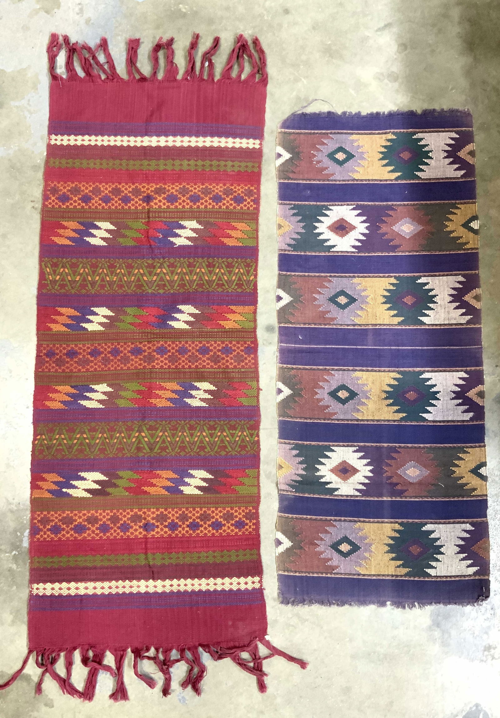Lot 2 Handmade Tribal Style Table Runners: Lot includes 2 table runners each have different tribal style geometric detail. Runners appear to possibly be handmade. Largest runner measures approximately 48 inches long 17 inches wide with fringes