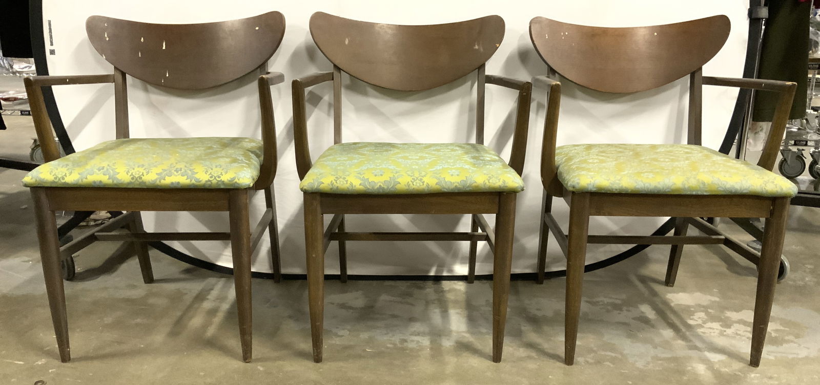 3 MCM Upholstered Wood Dining Chairs: Chairs have brown toned wooden frames. Each are mid century modern. Chairs each have green toned floral motif detail. Chairs measures approx 32 inches tall 22.5 inches wide & deep. Chairs, end chairs,