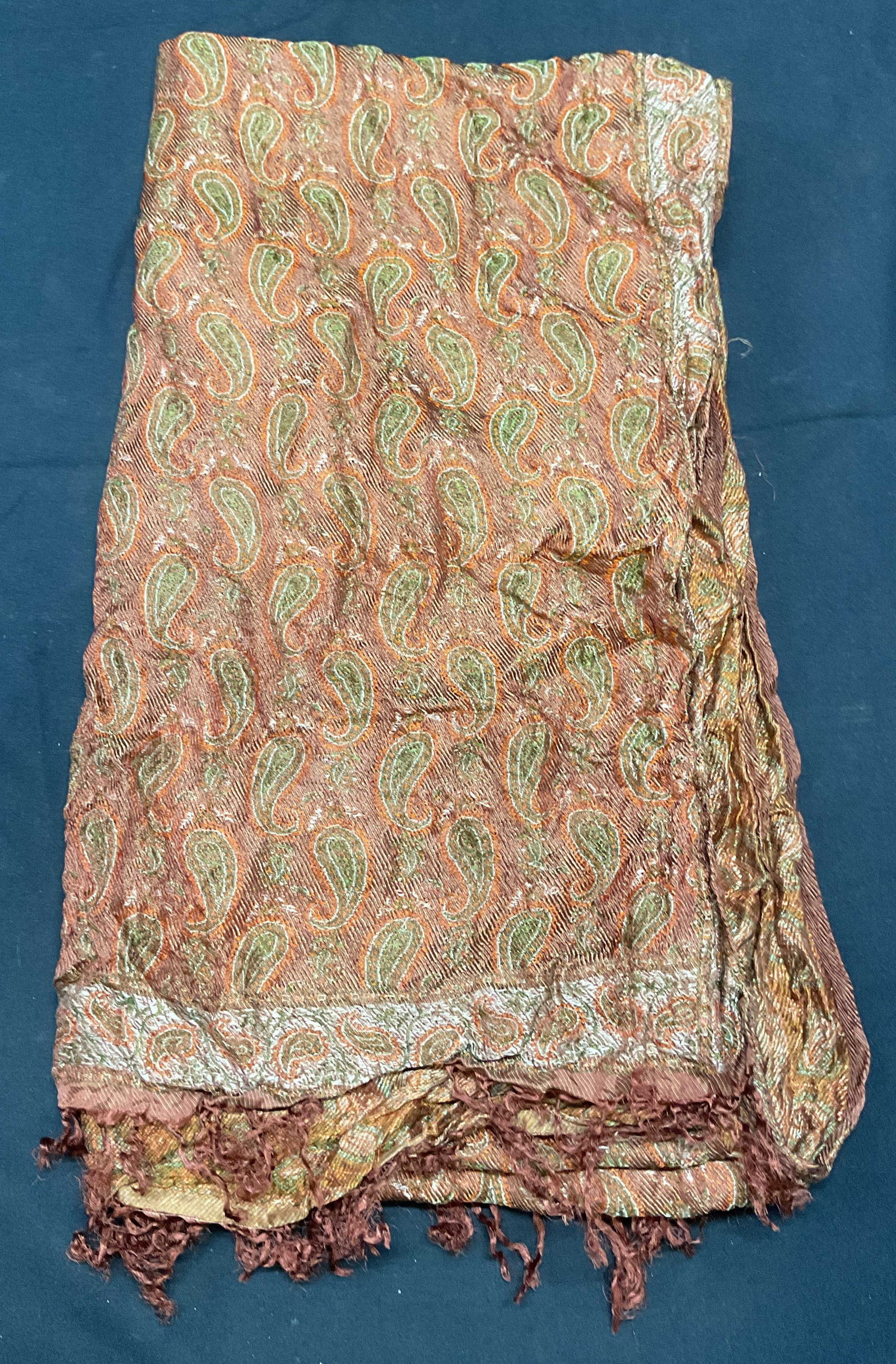 Orange paisley Print Fringe Scarf: Orange paisley print scarf with fringe trim. Possibly silk. Measures approx. 66 inches long. Some wear to material including blemishes observed. Ladies scarf, ladies orange scarf, ladies paisley scarf