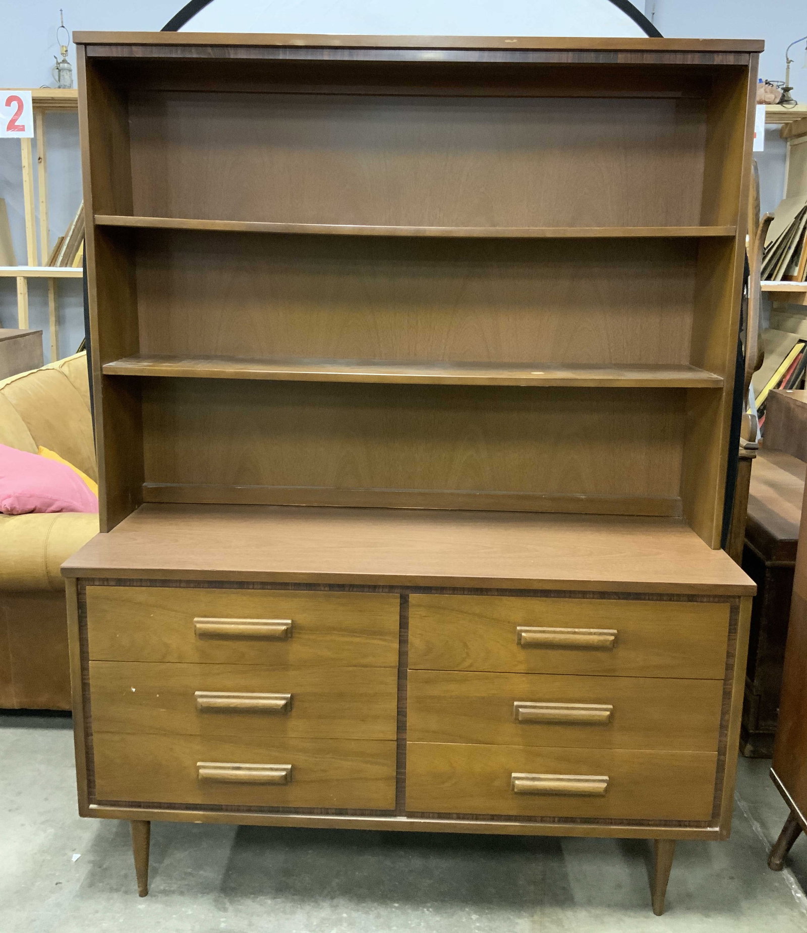 BASSETT FURNITURE MCM Dresser W Shelves: Interior of drawer reads BASSETT FURNITURE INDUSTRIES INC. Backside reads DRESSER. Piece is beige toned and wooden. Dresser is mid century modern. Base has 4 tapered wooden legs. Top half of piece has