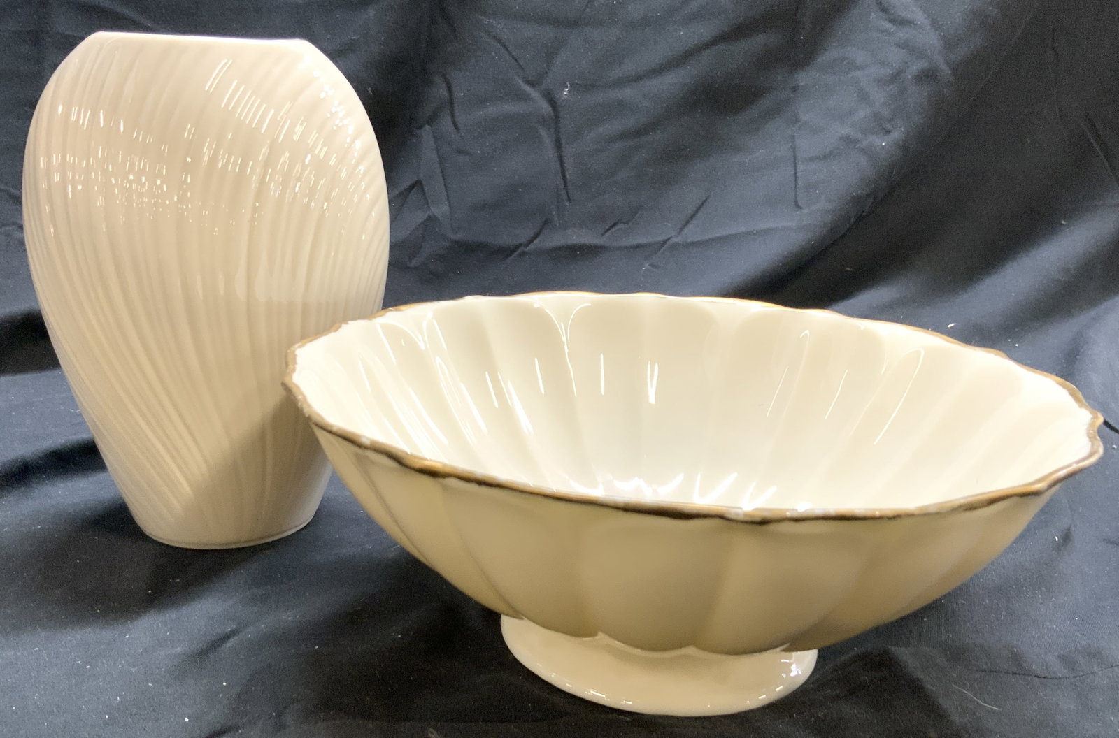 Lot 2 LENOX Porcelain Scalloped Bowl & Vase: Undersides are marked LENOX. Lot includes 1 bowl and 1 vase. Bowl is footed & scalloped. Piece has gilt rim. Vase has textural relief detail. Each piece is cream toned and porcelain. Bowl measures app