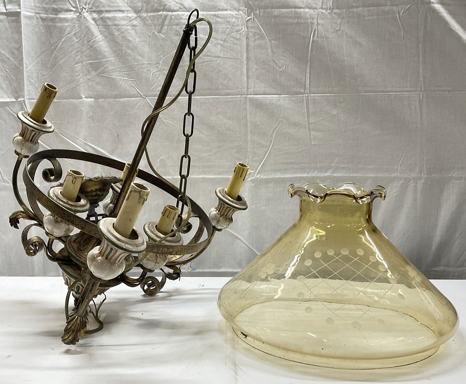 Vintage Six Arm Chandelier W/ Yellow Glass Shade: A vintage six arm gilt metal and ceramic chandelier. Scrolled metalwork designs. Comes with a glass shade. Yellow glass shade measures approx. 10.5H x 16W in. Not tested for function. Discoloration, s