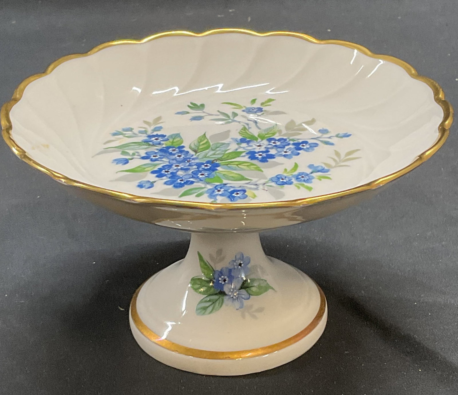Vintage Limoges Porcelain Tazza, France: Vintage Limoges porcelain tazza. Floral motif in blue. Hand painted gilt decoration. Signed on underside. Made in France. Measures approx. 5.5 x 3 inches. Surface wear including scratching and loss to