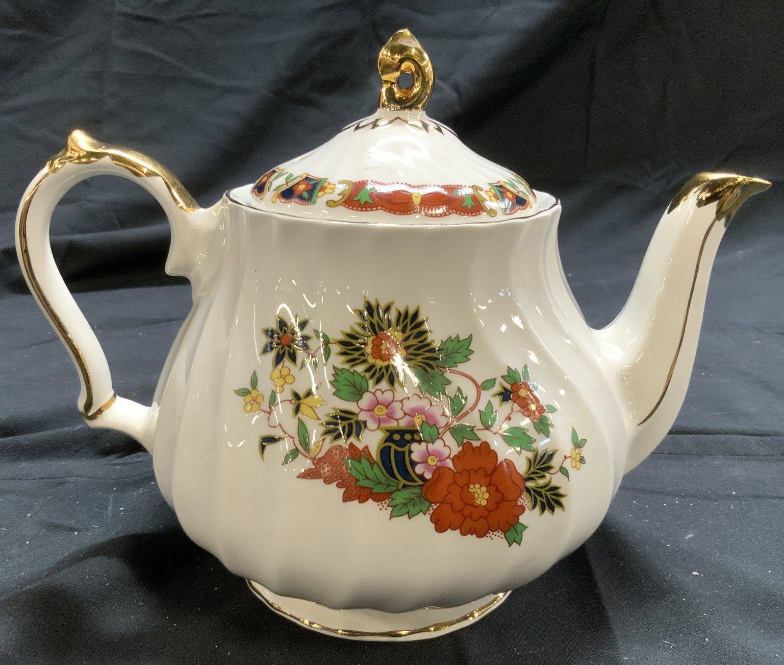 SADLER ENGLAND Vntg Porcelain Teapot W Lid: Underside reads SADLER ENGLAND. Piece is white with multi toned floral and leaf detail. Teapot is footed & includes lid. Piece also has gilt detail. Piece is vintage. Teapot measures approximately 8.5
