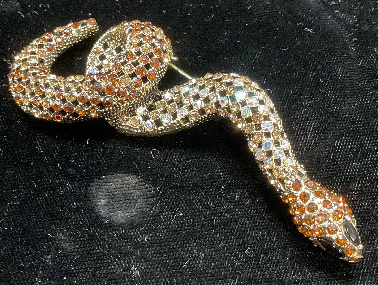 Gold Tone Crystal Snake Brooch, 3.5 Inches: Gold tone snake motif brooch/pendant with crystal decoration. Hinge pin and nail on underside. Measures approx. 3.5 x 1.5 inches. Some surface wear including scratching observed. Jewelry, estate jewel