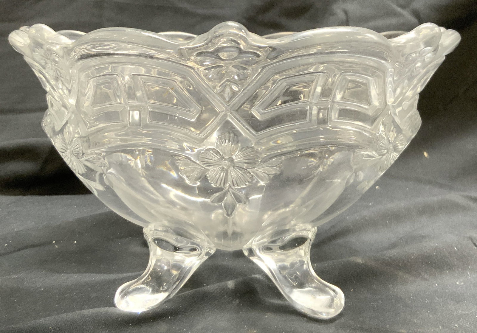 Footed Art Glass Bowl Vessel: Bowl is footed with 4 feet. Piece has floral and leaf relief detail. Bowl has uniquely formed rim. Bowl is glass. Vessel measures approximately 8.5 inches wide 5 inches tall. Bowl, vessel, glass bowl,