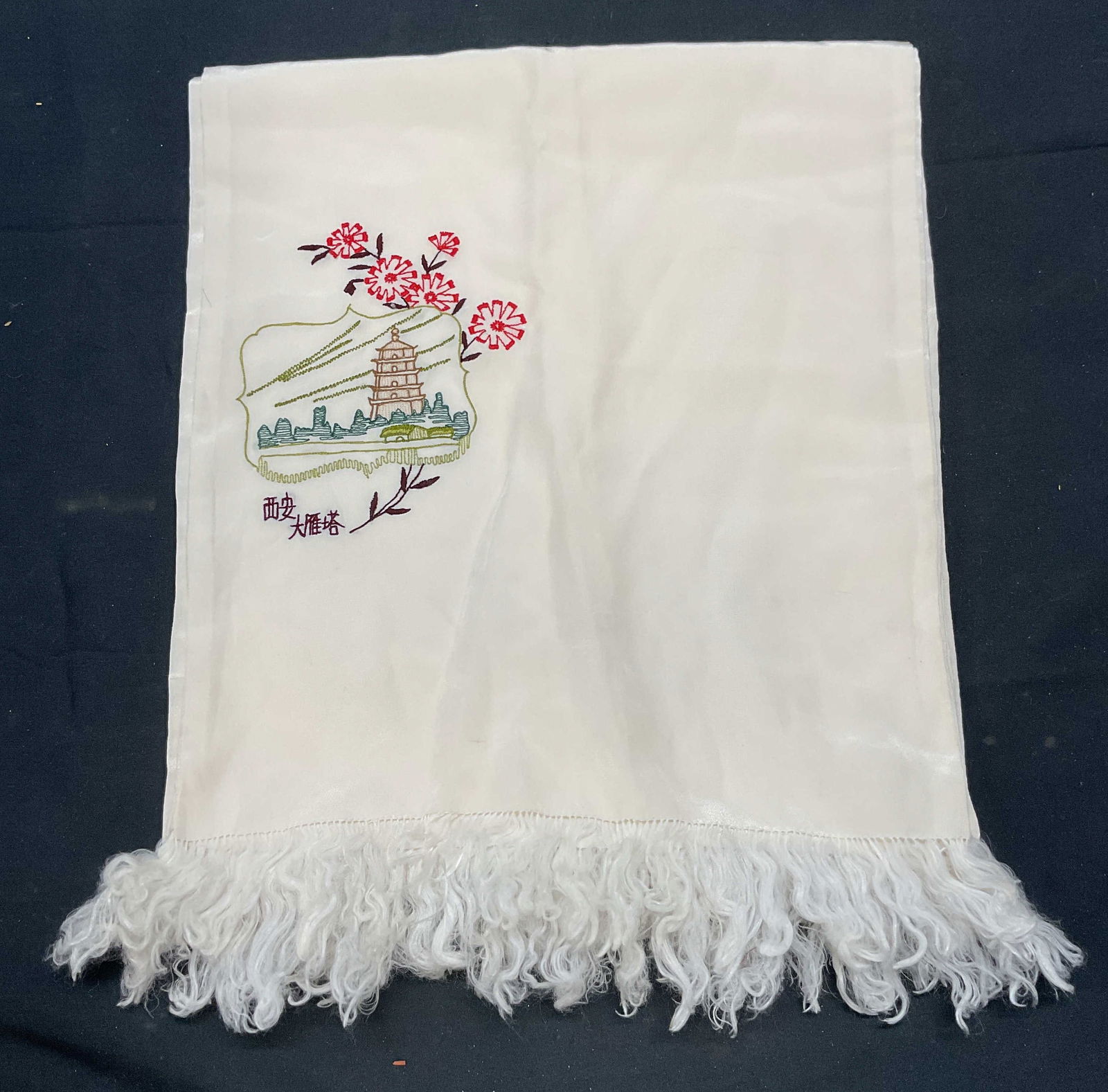 White Embroidered Asian Pagoda Fringe Scarf: White scarf with fringe. Embroidered Asian design with pagoda and floral motif. Measures approx. 50 inches long. Material feels like silk, possibly synthetic. Some wear to material including blemishes