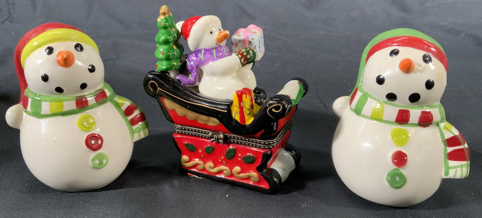 Snowman Sleigh Trinket Box & Salt & Pepper Shakers: Ceramic snowmen salt & pepper shakers. Snowmen sleigh ride trinket box with bow motif buckle. Trinket box depicts a snowman in a sleigh with a small tree and presents. Snowmen salt and pepper shakers,