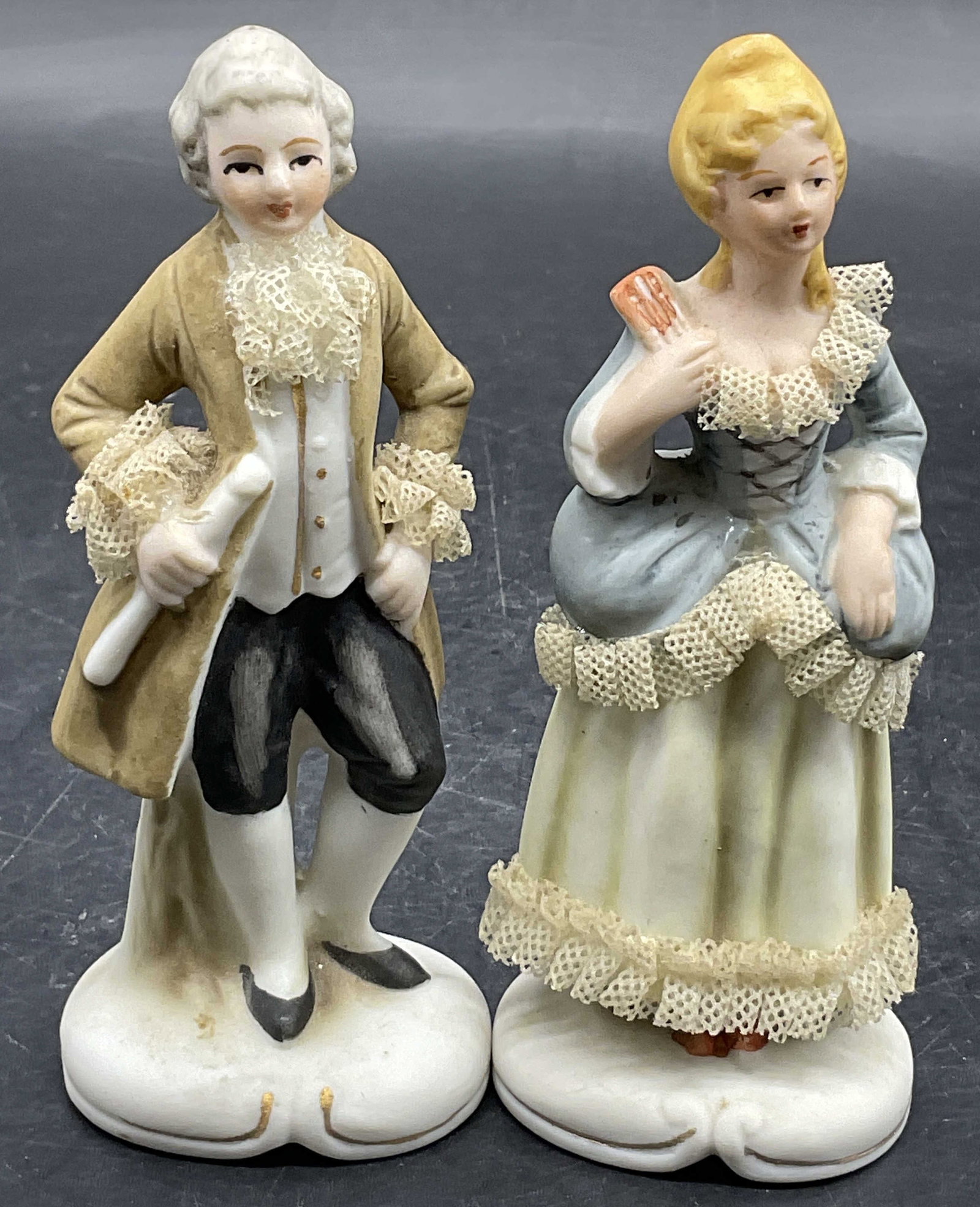 Lot 2 Vintage Porcelain Male & Female Figurals: Two vintage porcelain figurals, one make and one female. Both pieces feature lace porcelain details and hand painted elements. Male figural measures approx. 4.5H x 2W in. Drilled holes to undersides. 