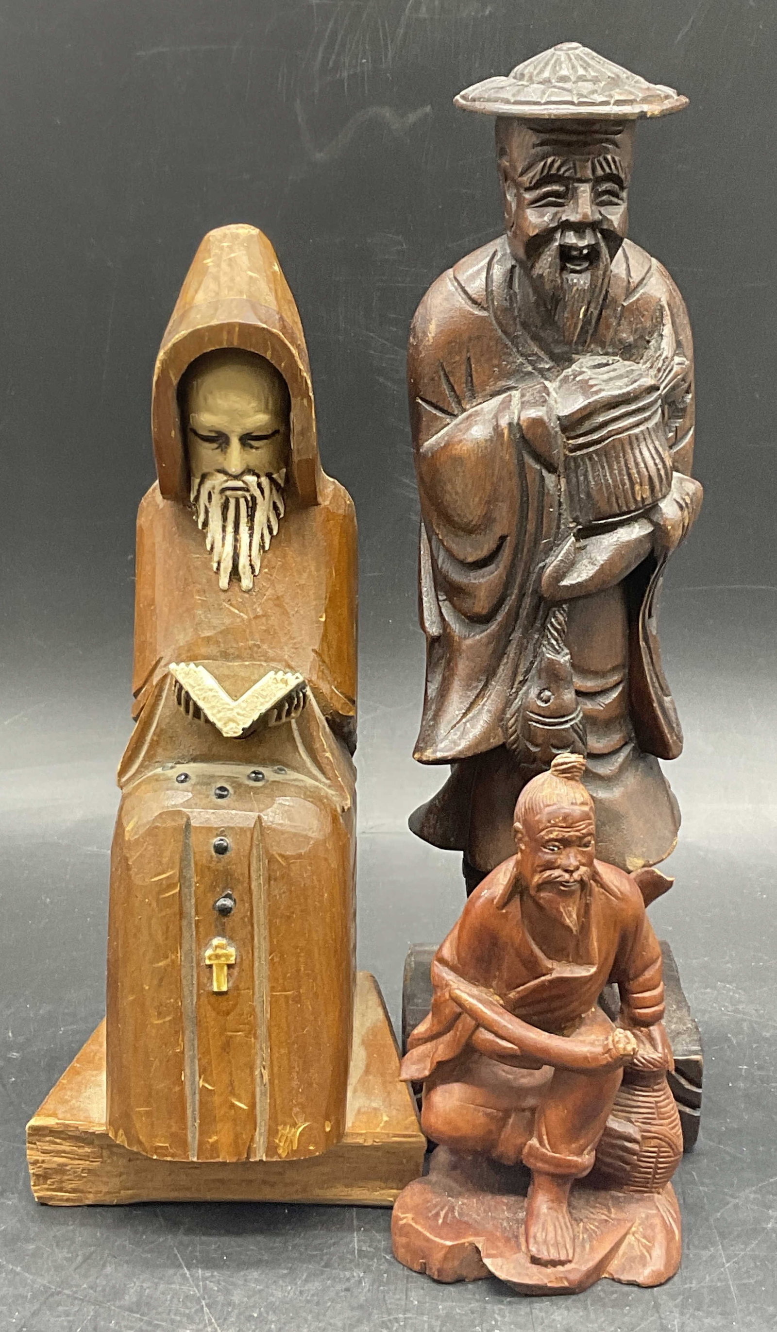 Lot 3 Carved Wood Male Figurals: Three carved wood male figurals. Tallest measures approx. 9H x 2.5W in. One figural holds a book, the book appears to be removable. Surface wear, losses, and chipping present. home decor, home accents