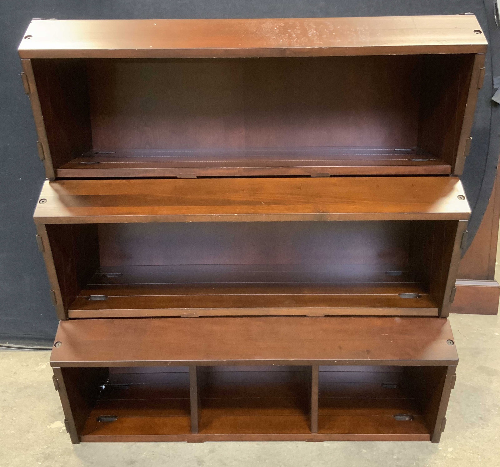POTTERY BARN KIDS Wooden 3 Tier Wall Shelf: Tags on backside read POTTERY BARN KIDS. Wall shelf is brown toned, appears to be wooden possibly veneer. Piece has 3 tiers. One tier is divided into 3 sections. Measures approx 35.5 inches tall 32 in