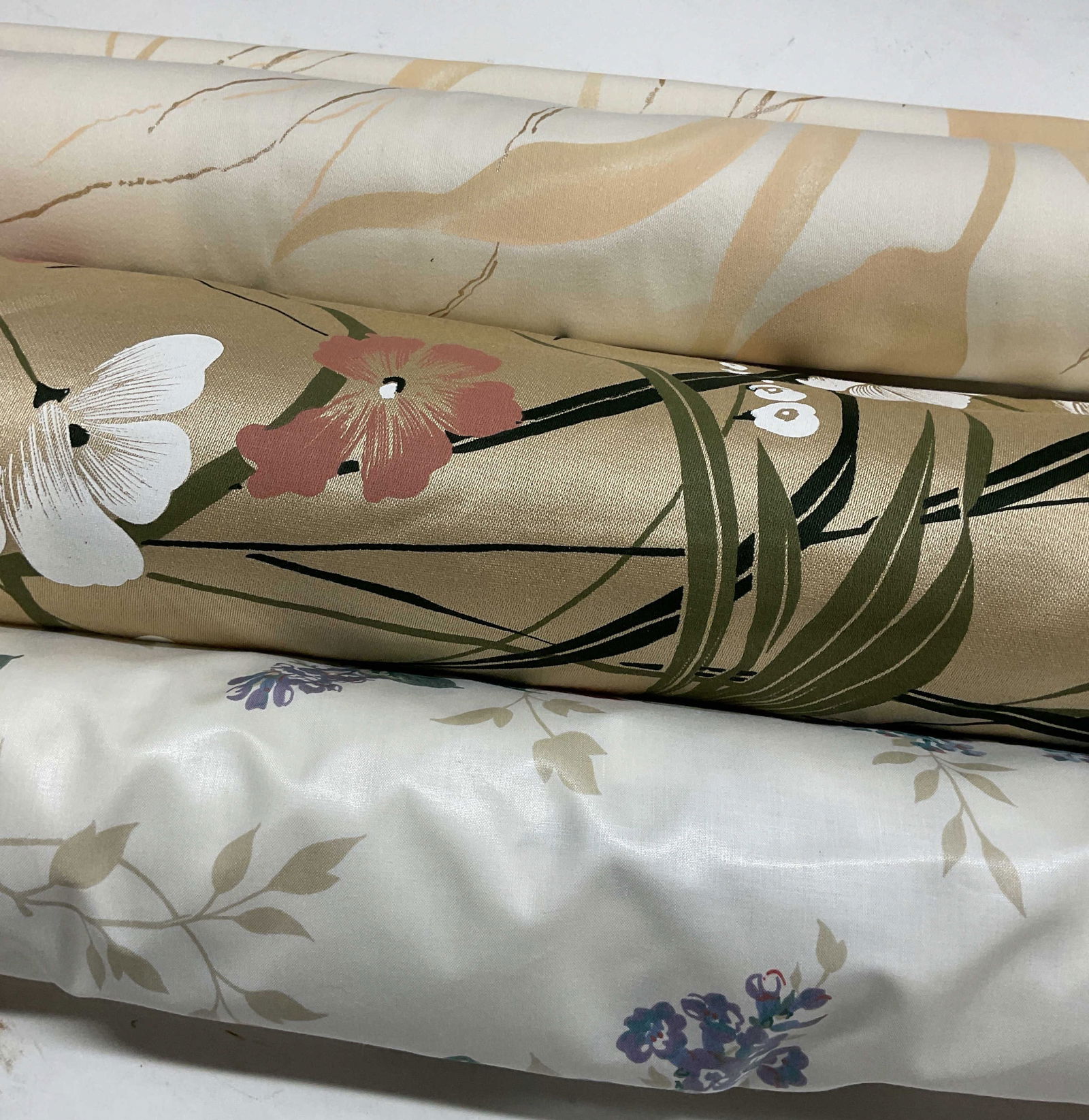 Lot 3 Gold & White Floral Print Fabric Bolts: Lot of 3 bolts of fabric. White and gold floral print fabric. Feels like cotton. Length not measured. Widest approx. 55 inches. All pieces have wear including discoloration and blemishes. Fabric bolt,