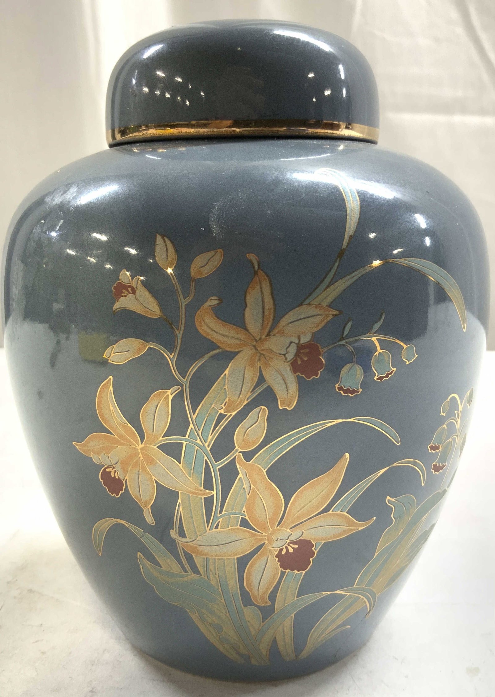 Signed Asian Porcelain Urn W Lid JAPAN: Underside is signed with red toned Asian characters on underside & reads JAPAN. Urn includes lid piece has multi toned & gilt floral and leaf detail. Vessel measures approximately 6 inches tall 4.5 in